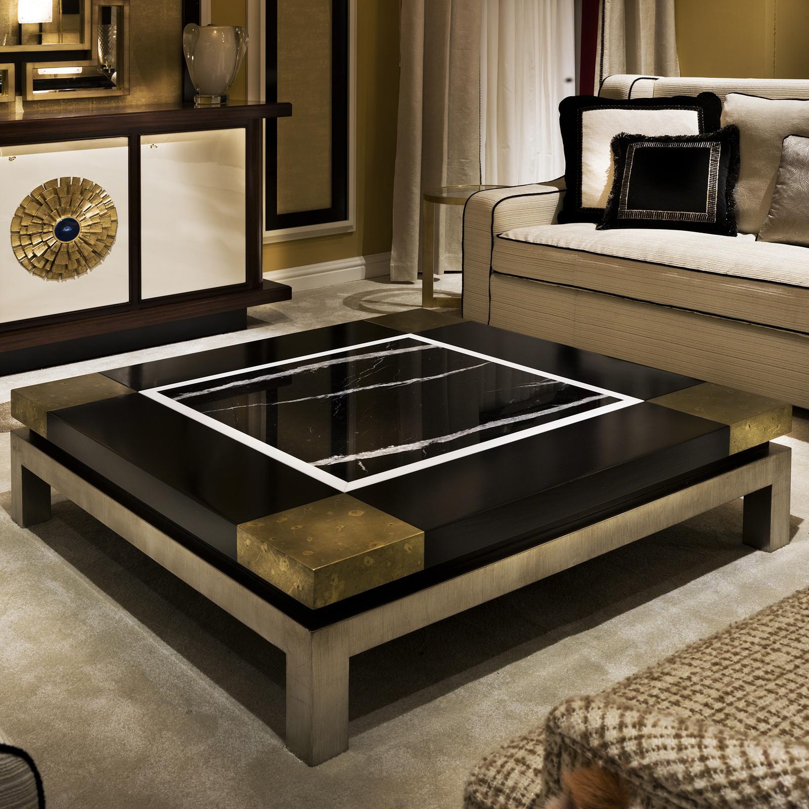 A magnificent piece of functional decor, this coffee table is sure to make a statement in any decor. Its large, square base is in wood and was hand painted with silver leaf. The wooden top was painted by hand in black with corners in gold leaf. The