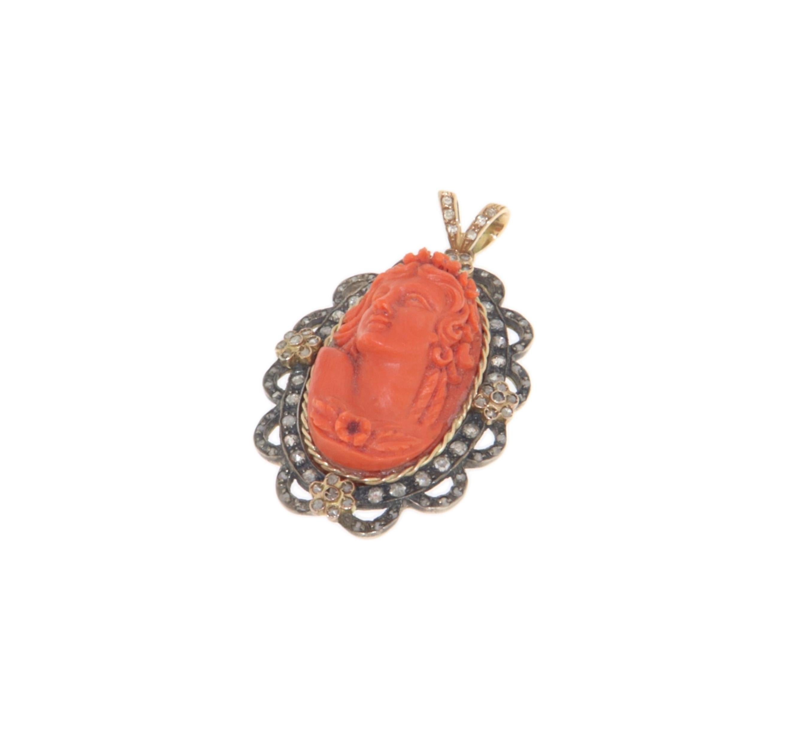 This pendant is a miniature work of art, crafted in 14-karat yellow gold and 800-millesimal silver, with a design rich in details that combines tradition and refinement. At the center of the pendant is a masterfully carved natural coral, depicting a