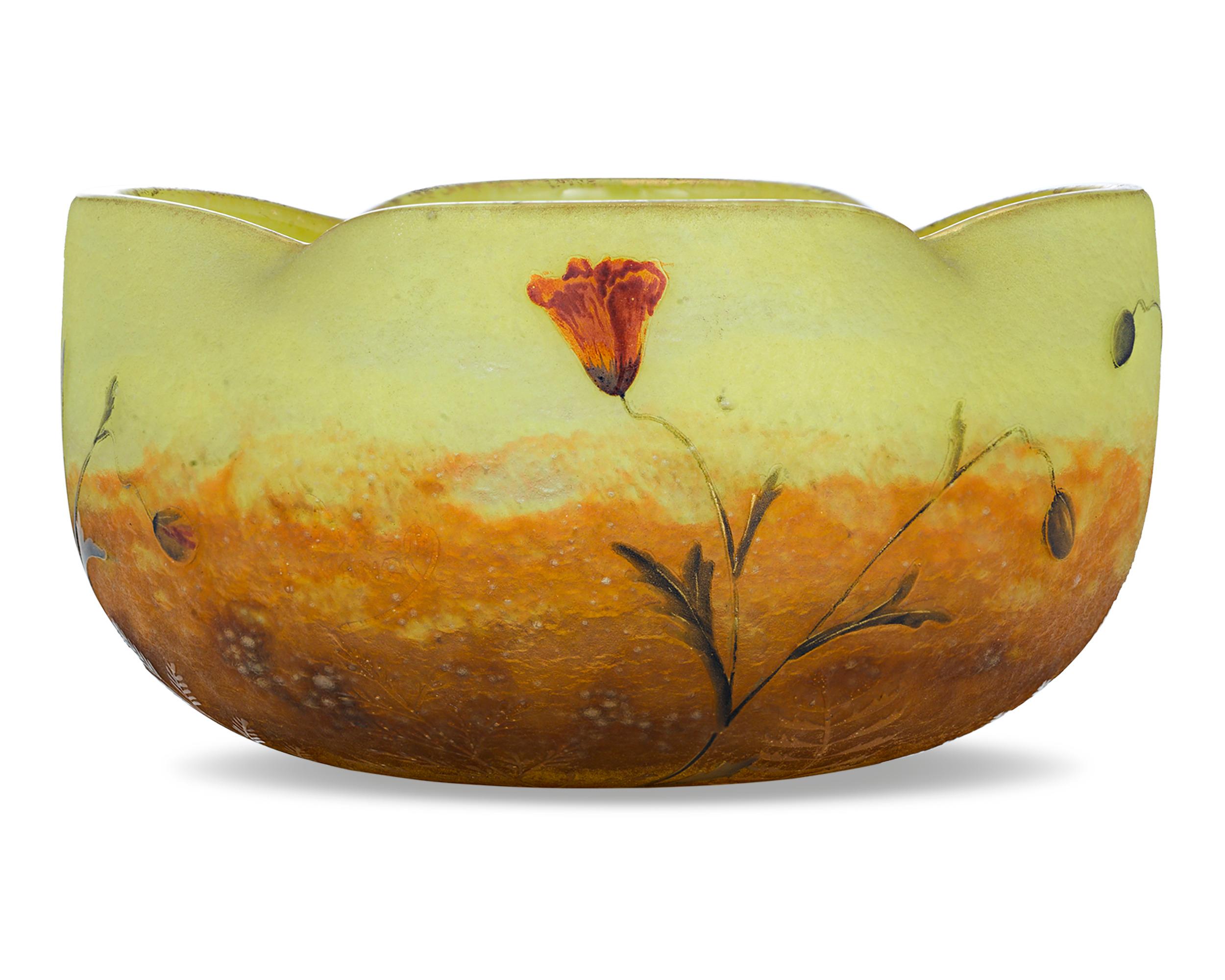 Wildflowers are in bloom on this rare cameo art glass bowl by the renowned French glassmaking firm of Daum, Nancy. The graceful vessel features a wavy-edged rim and delicate, wistful flowers residing upon a sunset background of yellow and orange.