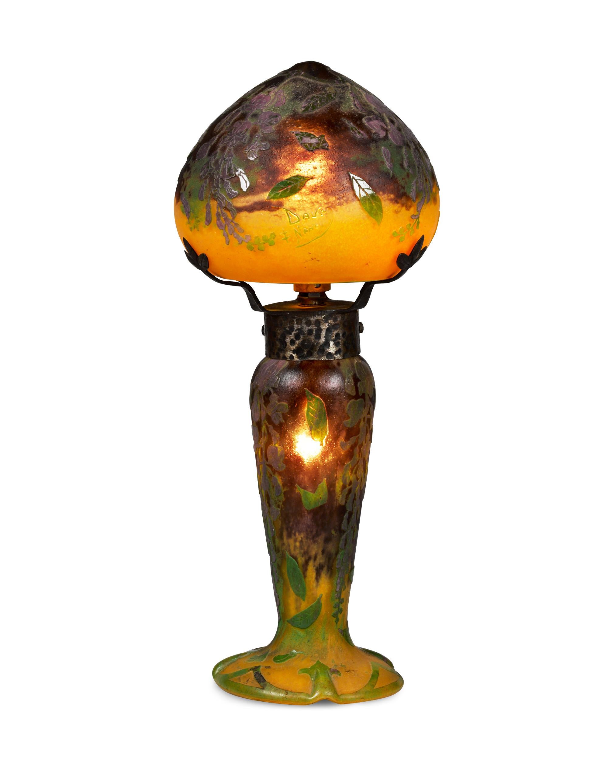 Elegant blooms grace this exceptional ovoid shape cameo glass lamp by the celebrated French glassmaking firm, Daum Nancy. Careful wheel-carving and acid-etching reveal layers of vibrant color in this magnificent celebration of Art Nouveau