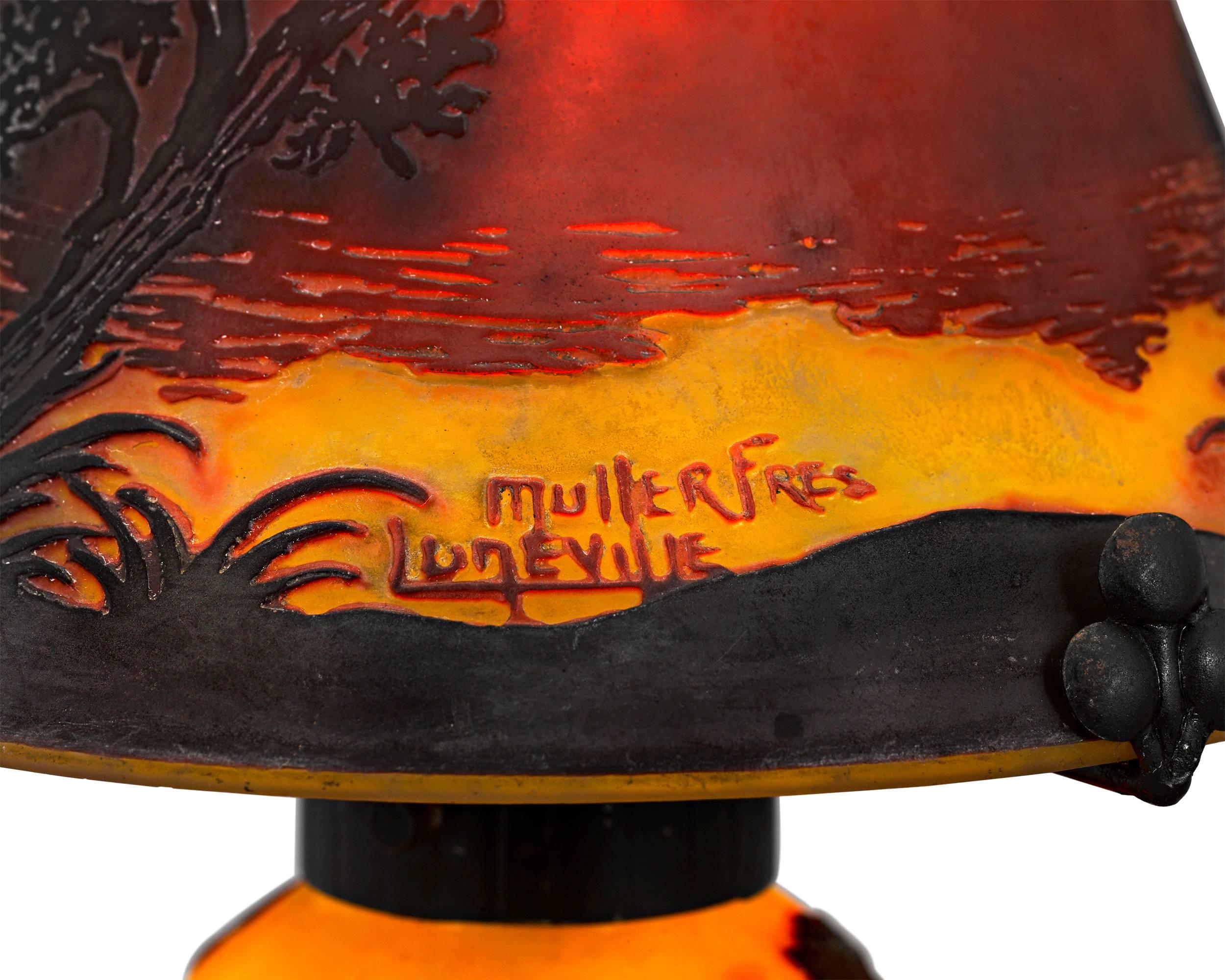 This eye-catching cameo glass lamp from the celebrated Muller Frères glassworks is an exquisite example of the art form. The shade and base are executed in vibrant shades of orange, yellow and terra cotta, which come together to create the