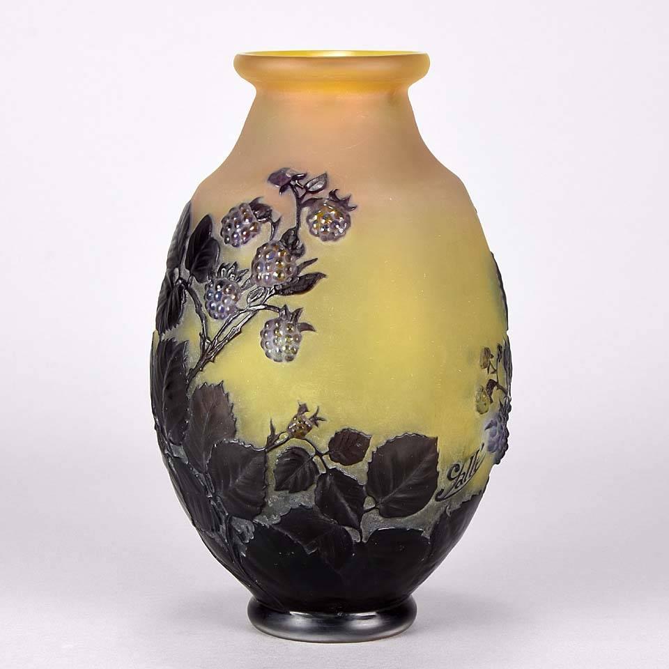 An important and rare early 20th century Art Nouveau French cameo glass vase with an impressive fruiting design overlay mould blown and hand chased with deep purple blackberries amongst thorny leaves against a yellow field, signed Gallé.