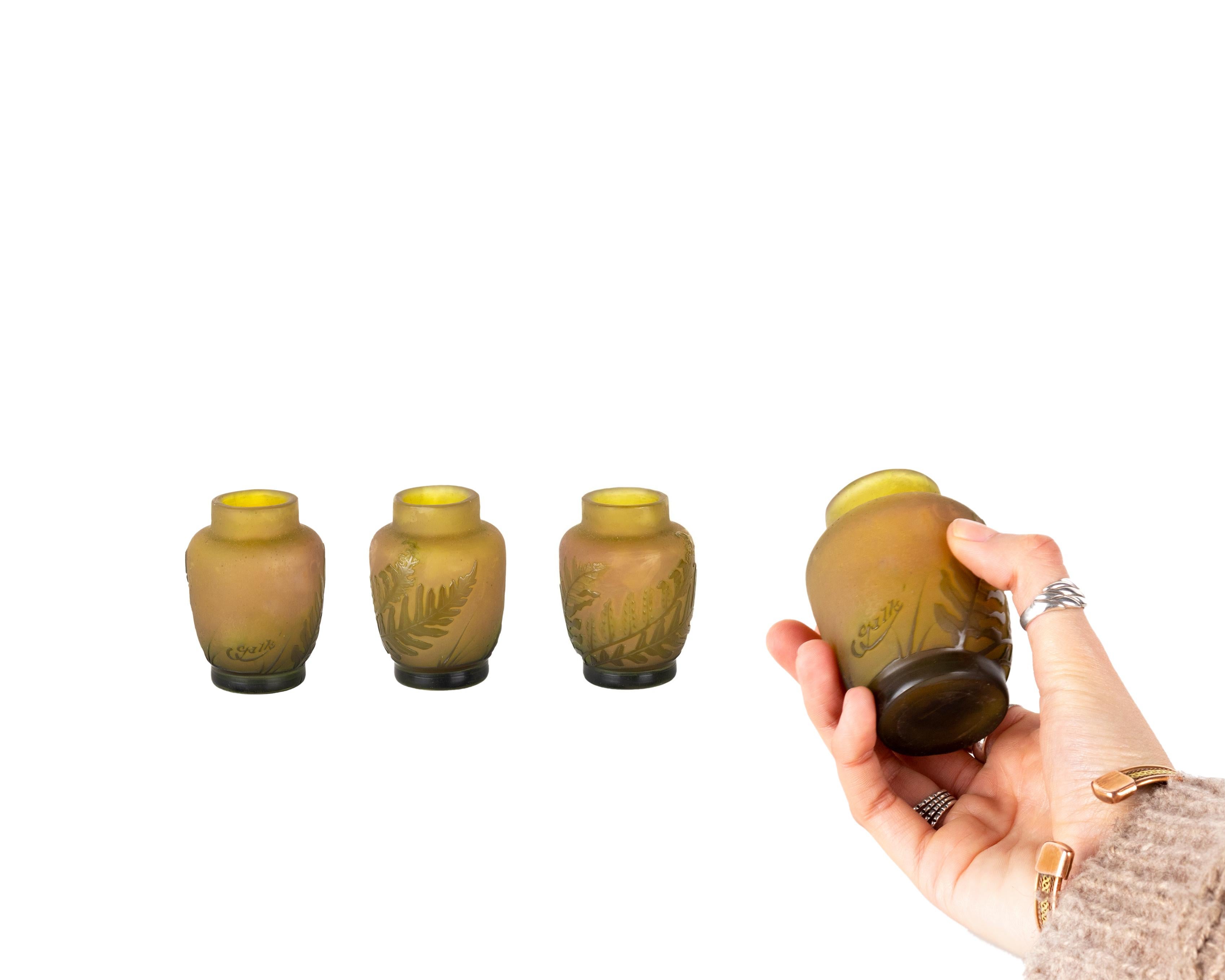 Vase mit Säureätzung, dekoriert mit grünen Farnen auf opakem Gelb
Hintergrund.  
Beim Kameenglas werden zwei Farben übereinander gelegt, so dass die Farbe der darunter liegenden Schicht sichtbar wird. 
Galle' unterzeichnet.
