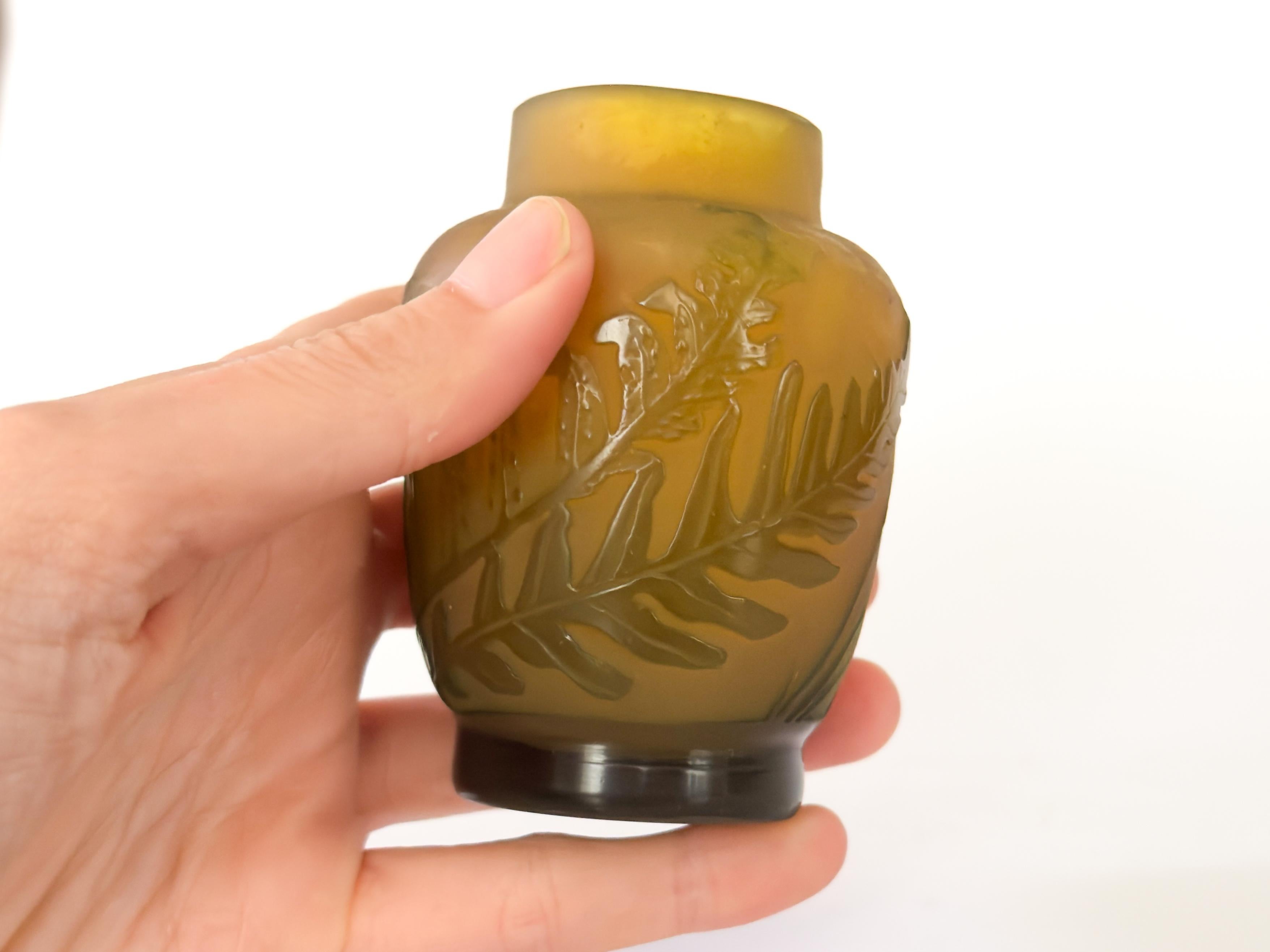 Un vaso acidato decorato con felci verdi sullo sfondo giallo opaco.  

Il vetro cammeo utilizza due colori stratificati, in modo da rendere visibile il colore dello strato sottostante. 

Galle' firmato.

Tieni presente che i colori degli articoli