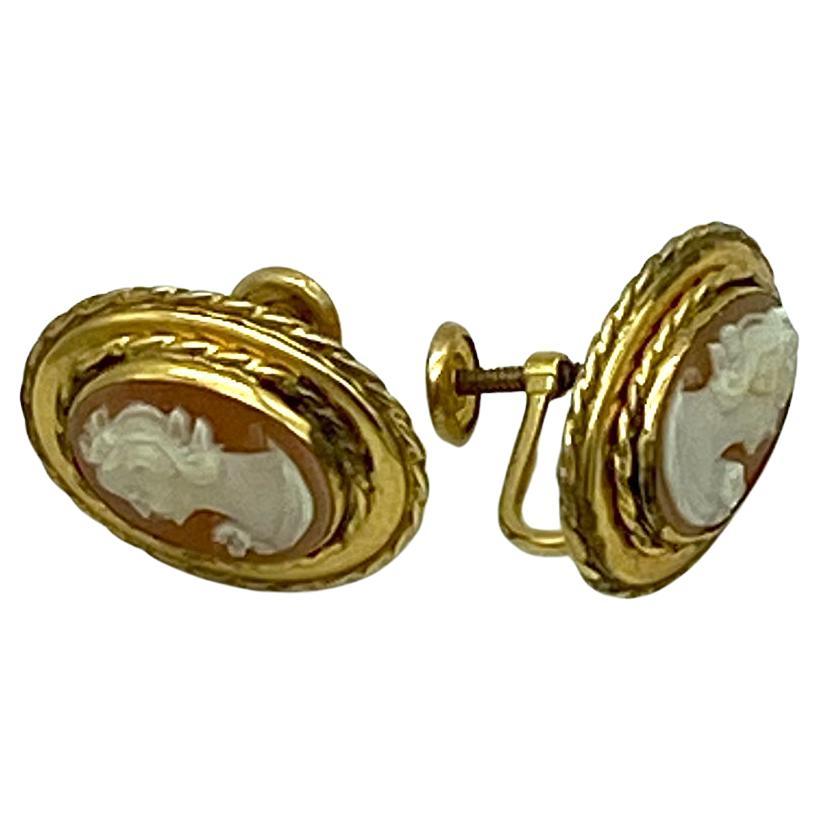 Dies ist ein Paar von Cameo Gold gefüllt Ohrringe. Sie sind 1940er Schraube zurück Ohrringe ein Paar von geschnitzten Muschel mit zwei kurzhaarigen Damen Profil Porträts mit Blumen und Lünette in markiert 12K Gold gefüllt Frames.

Unsere