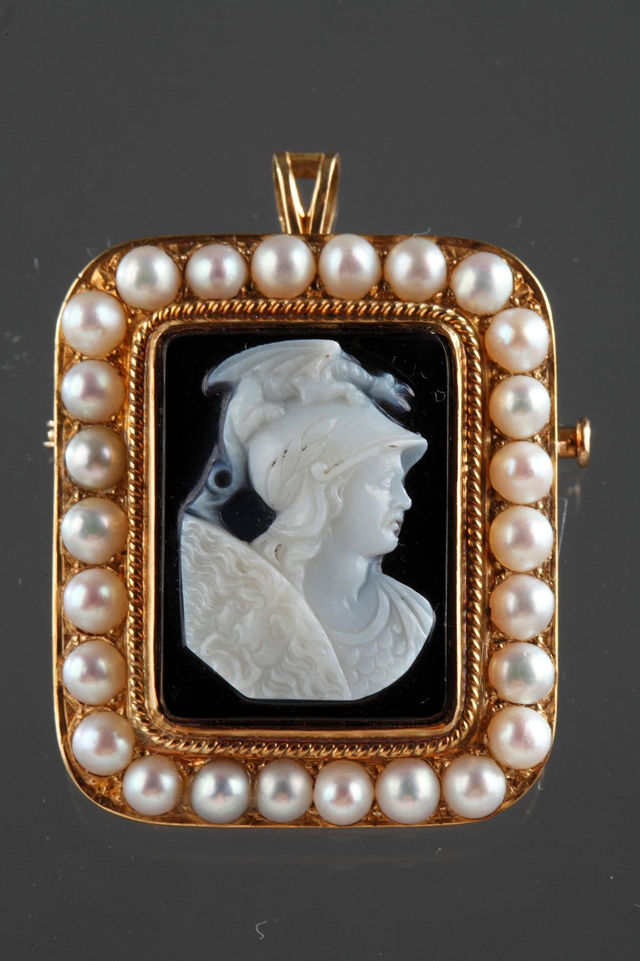 Brown agate cameo featuring a young man wearing a helmet and looking toward the right. The artist intricately sculpted the white vein of the agate to bring the delicate profile to life. The character portrayed is Perseus, wearing his helmet with a