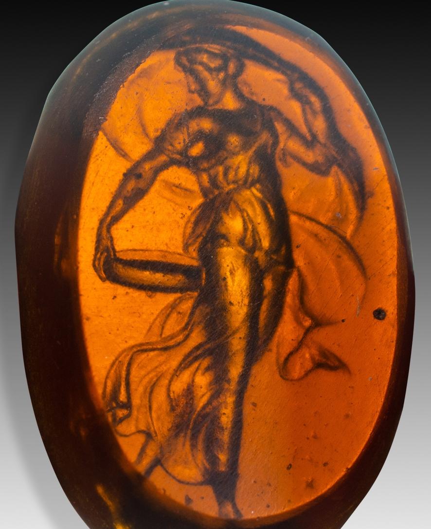  Camée ou intaille, danseuse. Le verre. Peut-être Italie, 19e siècle. 
La figure féminine, dans une posture de danse et tenant un récipient, peut être identifiée à une Maenad dansante. Ces êtres féminins divins apparaissaient dans le cortège du dieu