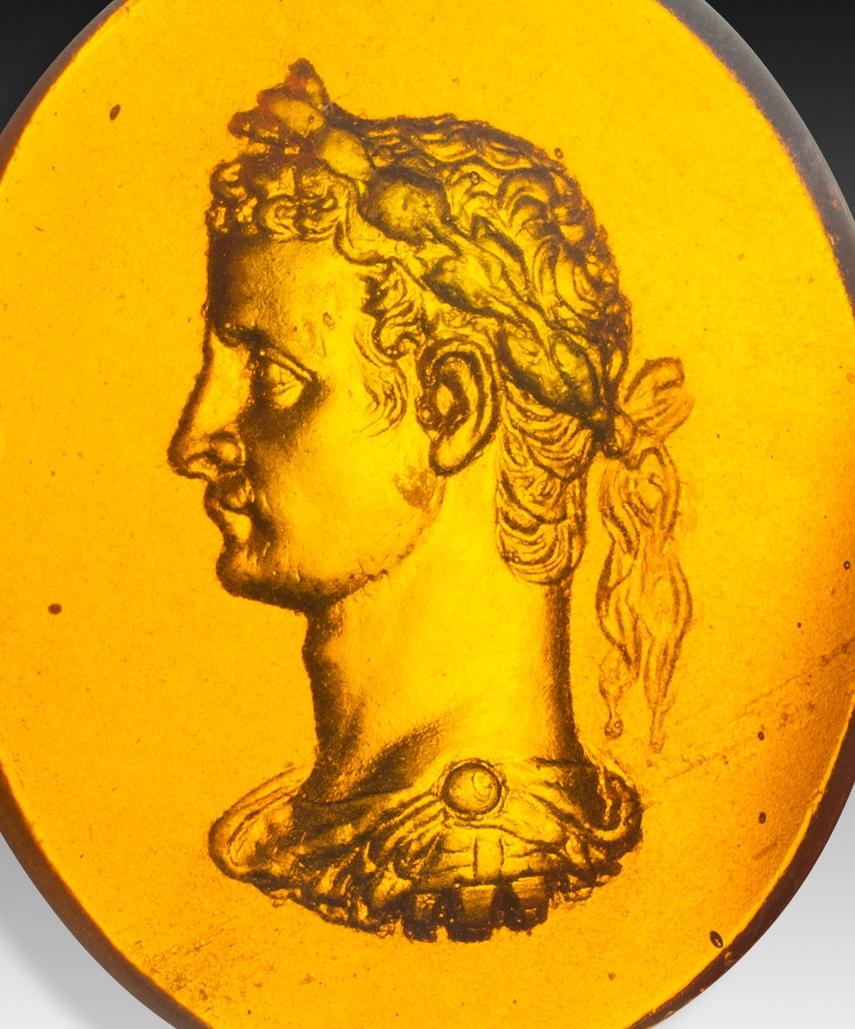 Camée ou intaille, empereur. Le verre. Peut-être Italie, 19e siècle. 
Profil d'un homme relativement jeune, vêtu d'une armure romaine et portant un diadème ou une couronne de lauriers, à la manière des empereurs de la Rome antique. Ces pièces ont