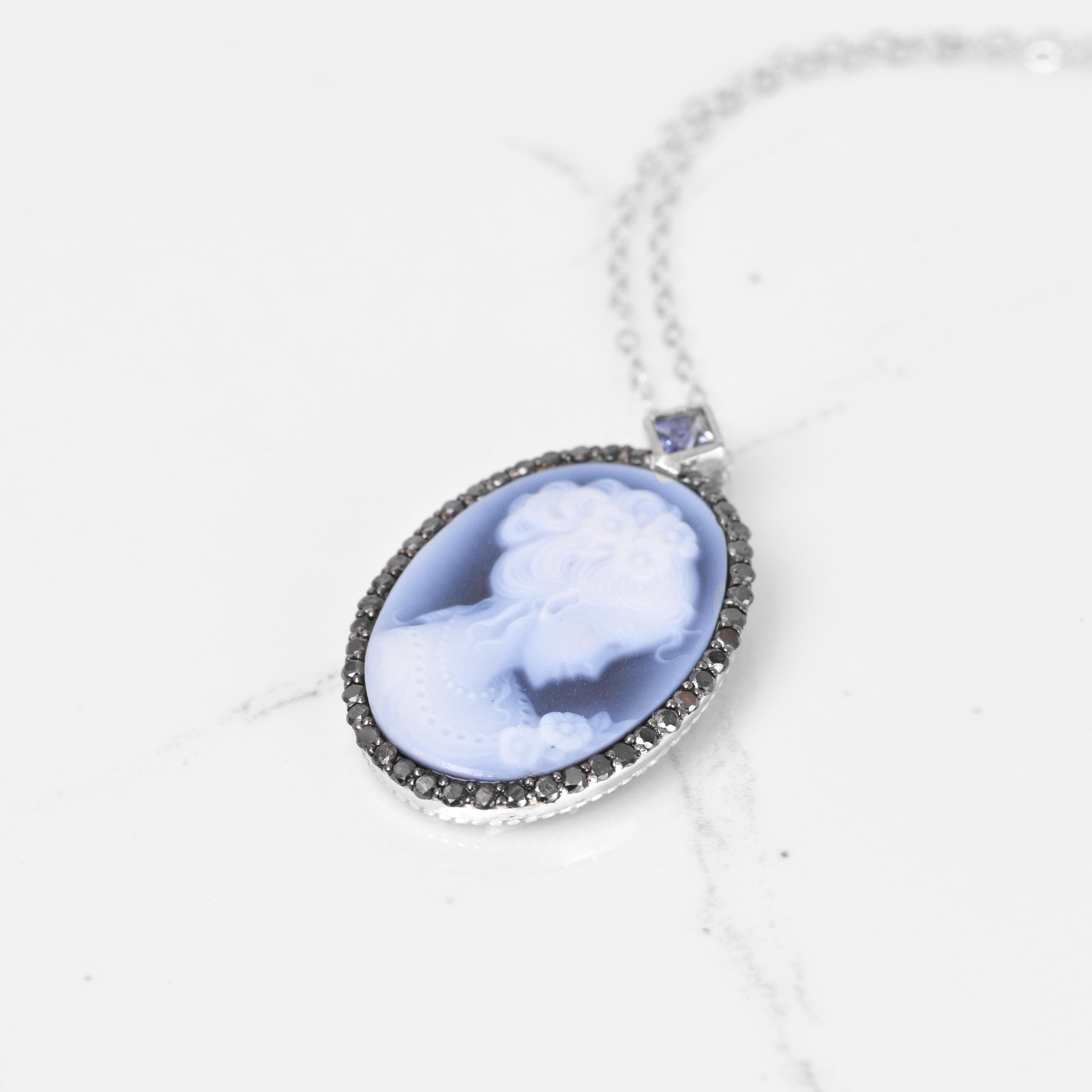 All the vintage feels with this gorgeous vintage inspired cameo pendant. Surrounding the beautiful cameo is a black diamond halo, and a blue sapphire accent. All set in white gold. The dimensions of this pendant are 32mm x 21mm.