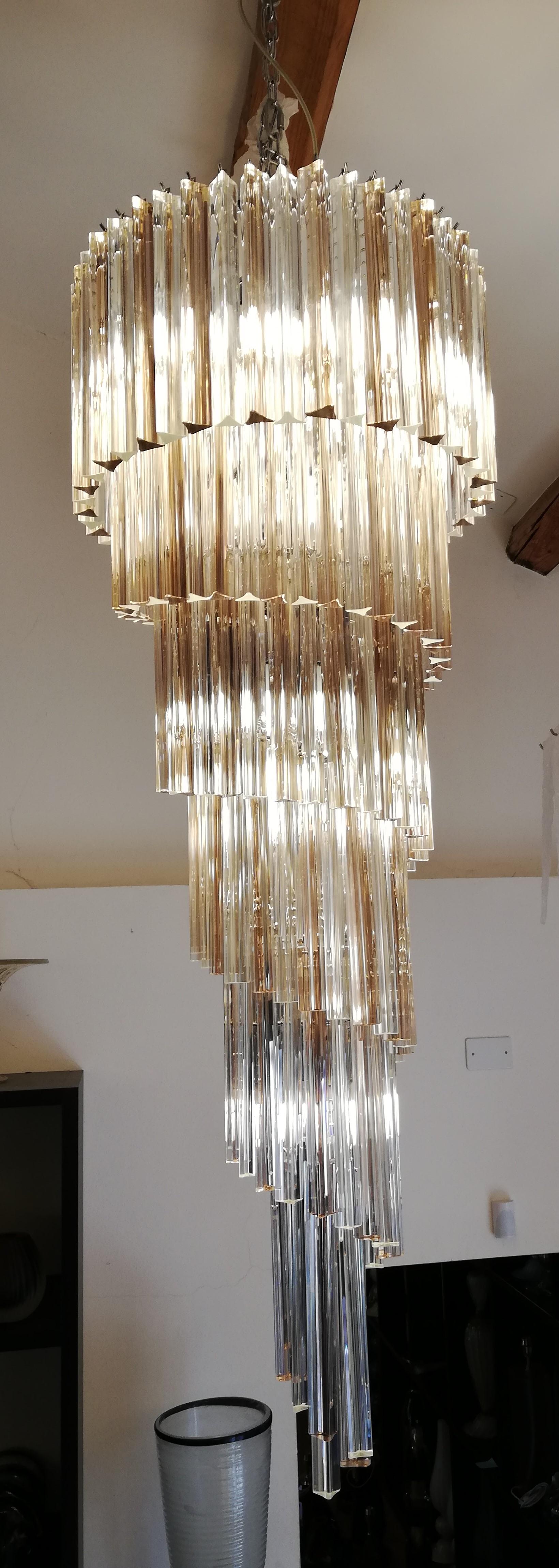 A beautiful and impressive chandelier suitable, due to its important height, to spacious rooms and high ceilings. 
The chandelier creates magnificent reflections of light thanks to the alternation of the 163 crystal and amethyst glass trios.