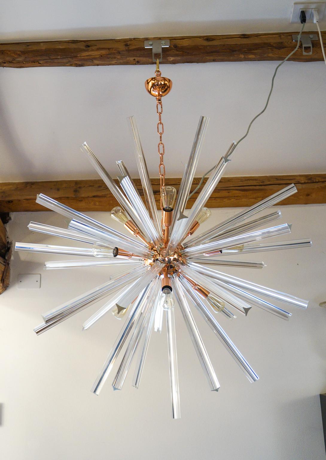 Designed in 1982 by Camer glass, this chandelier has 43 clear glass elements called “Triedri”.
Perfect for a modern space, the chandelier reach the diameter of 90 cm and is lighted by 9 Bubs E14 that create a comfortable atmosphere lighting the