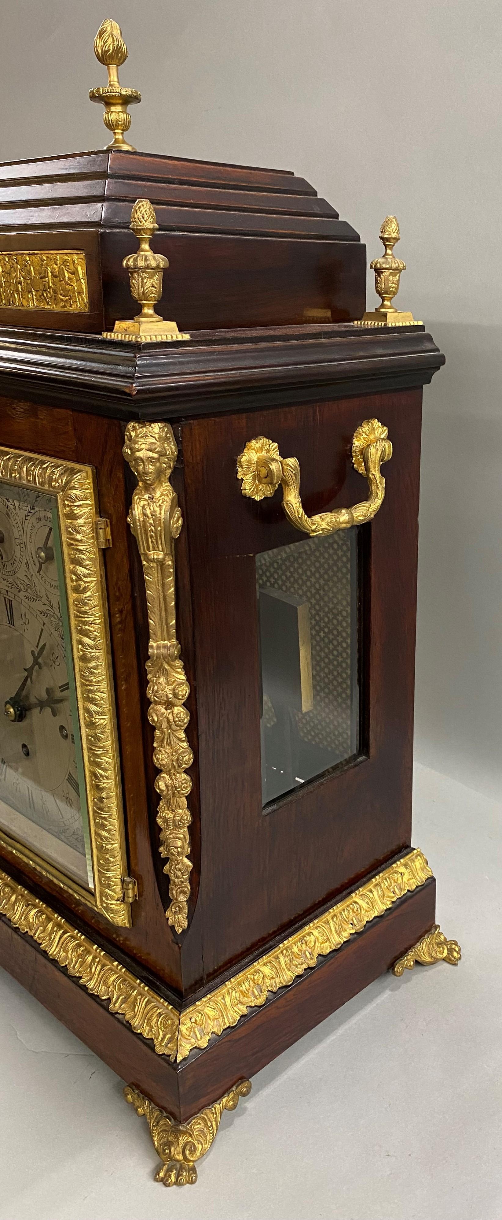 A fine example of an English ormolu mounted rosewood, musical bracket or mantle lock with manufacturer’s label for Camerer, Cuss, & Co, London. This beautiful clock has a silvered dial with Roman numerals, and Westminster chimes with eight bells.