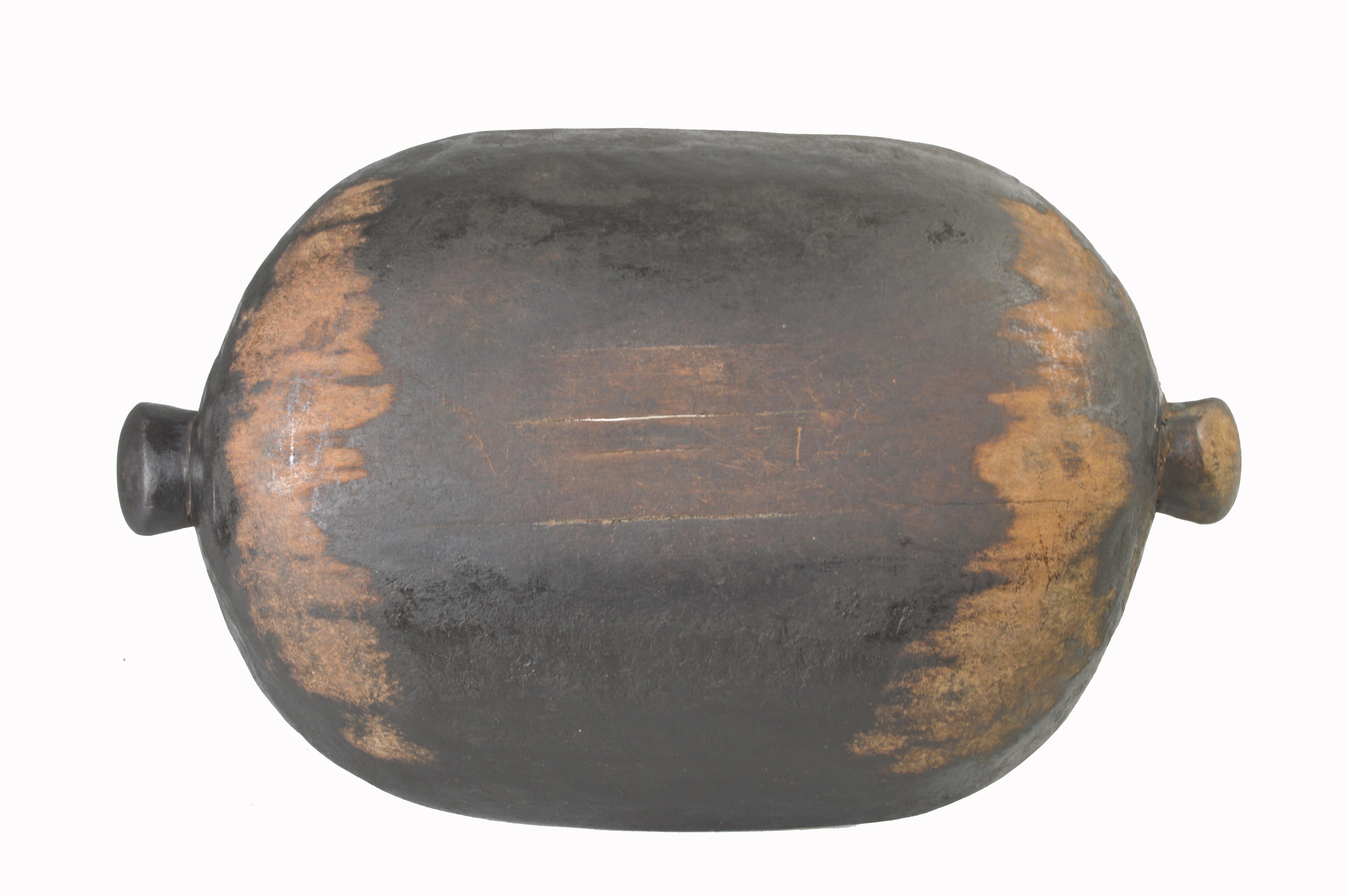 This is a large, early- to mid-twentieth century food bowl from the Grassfields peoples of Cameroon. The presence of spouts at either end of the bowl, its rich patina and extensive signs of use suggest that it was a vessel for serving moist stews