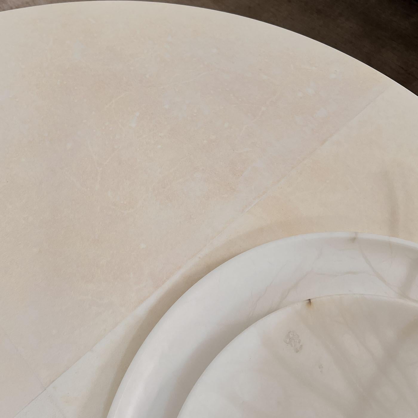 La collection de tables Camilla peut être fabriquée à partir de différents matériaux, tels que le bois teinté wengé, la loupe, le marbre ou d'autres pierres naturelles. Dans la version parchemin, l'élégance et le raffinement du matériau