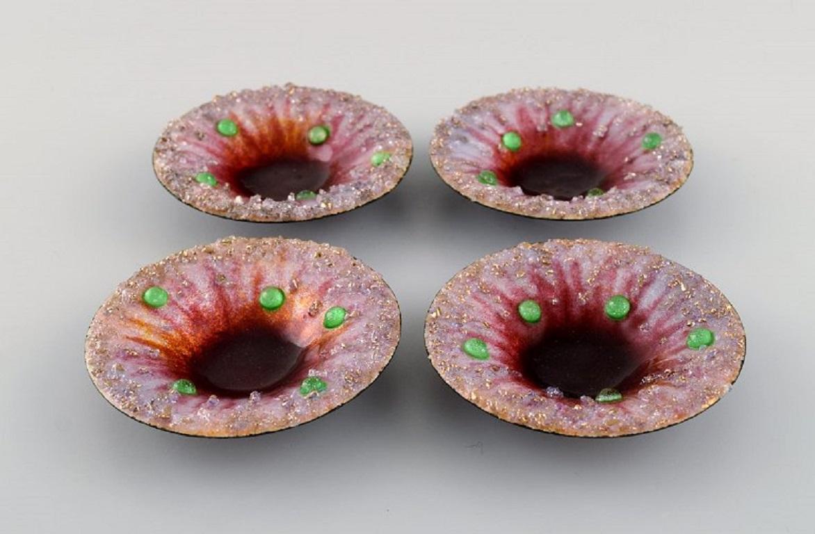 Camille Fauré for Limoges, France. Four Art Nouveau bronze bowls in enamel work. 
Green art glass stones inlaid on pink background. 
Ca. 1910.
The excellent Art Nouveau items of superb quality.
Signed.
In excellent condition.
Measures: 8 x 1.5
