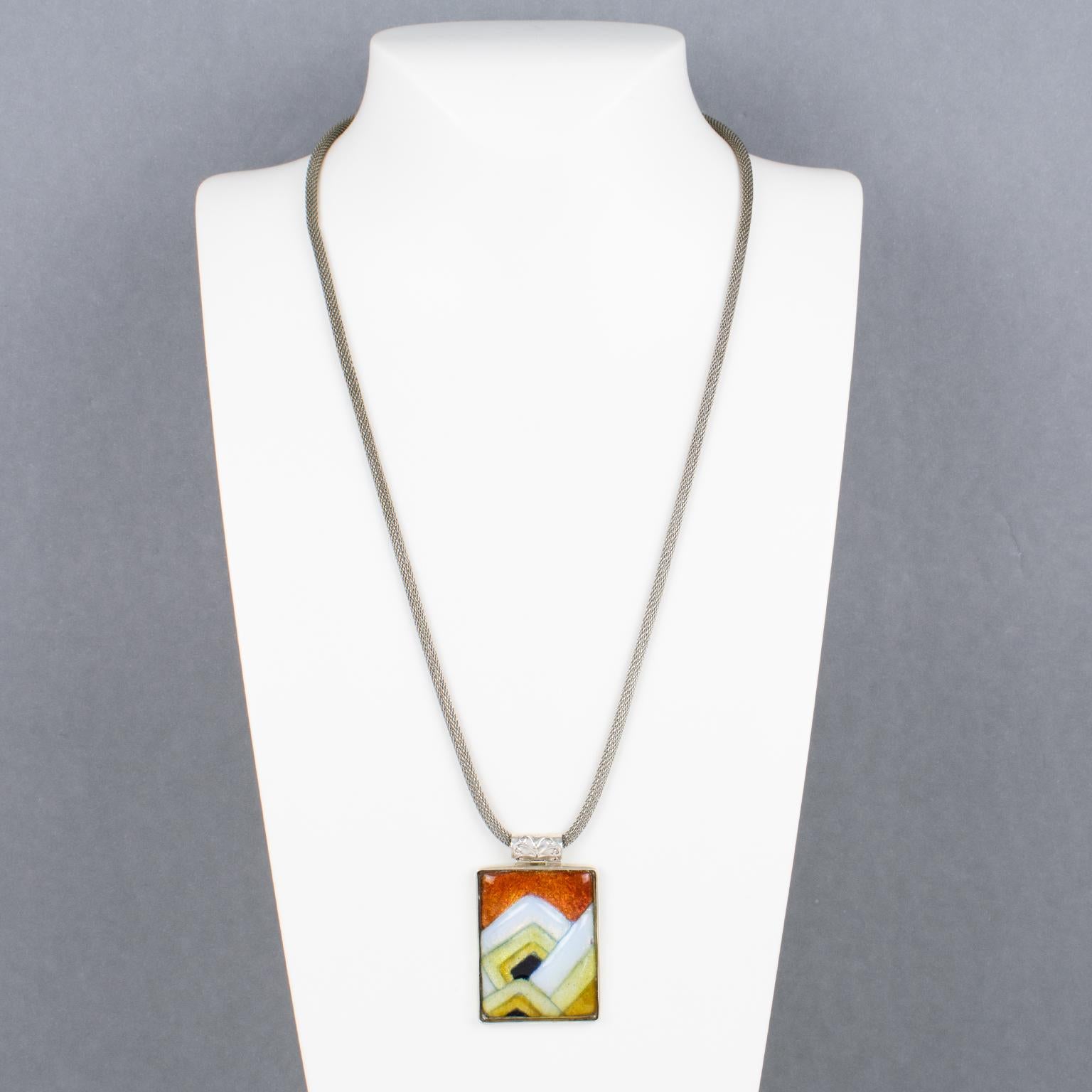 Questa elegante collana con ciondolo è stata realizzata a mano dall'artista smaltatrice di Limoges Mauricette Pinoteau. La cornice rettangolare in argento è ornata da un cammeo in smalto su rame. Il design di ispirazione Art Deco ha una forma