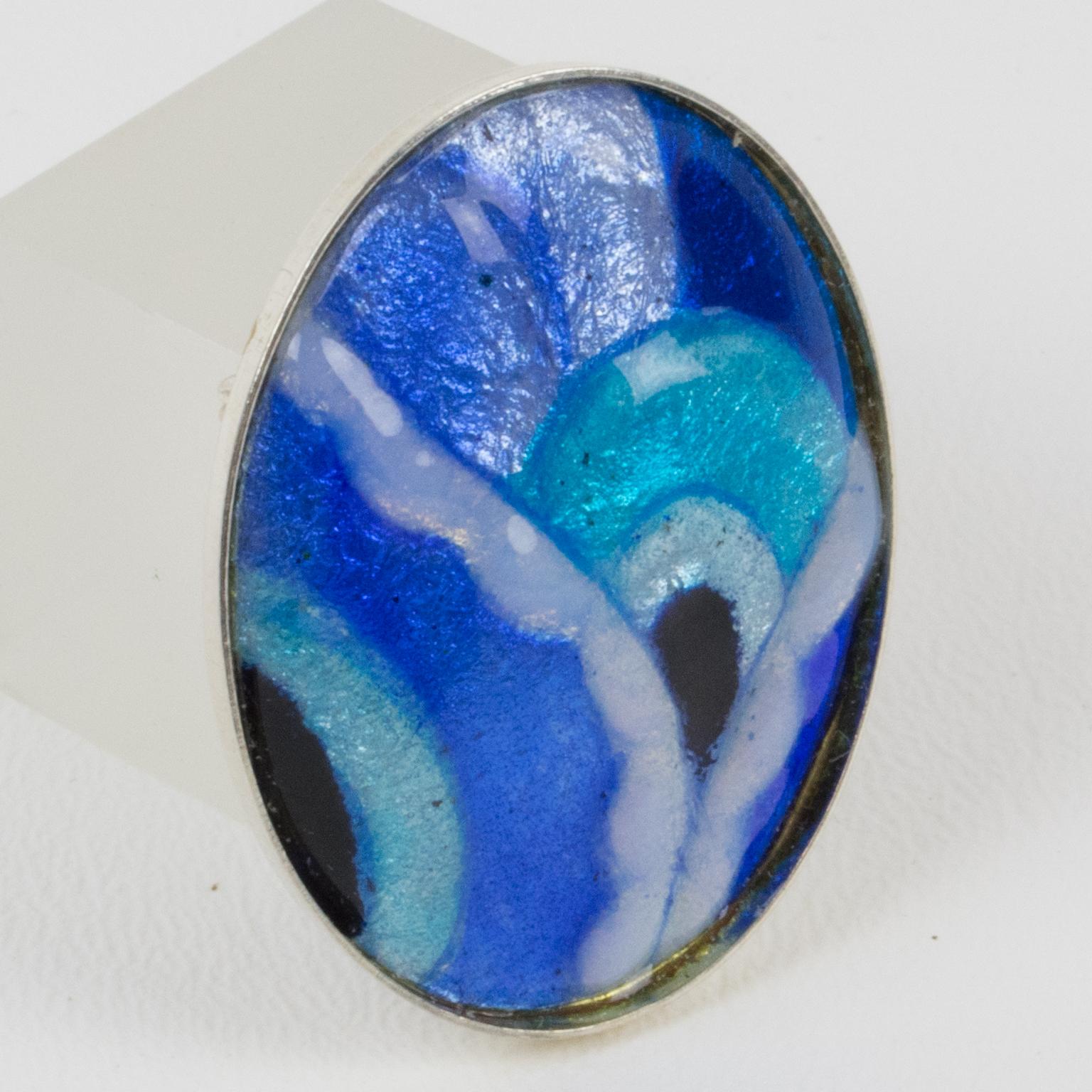 Romantic pin brooch by Limoges enamelist artist Mauricette Pinoteau. Ovoid sterling silver frame with an enamel-on-copper cameo. Art-Deco inspired design with a geometric shape. Assorted colors of cobalt blue and turquoise blue, navy blue, white and