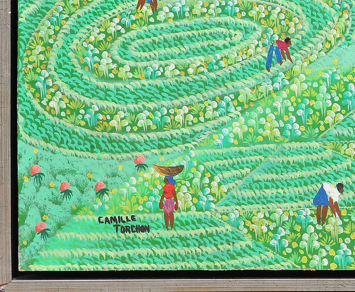Green and blue-toned folk art painting by Haitian artist, Camille Torchon. The painting depicts an early morning scene at the village by the sea, where people are seen harvesting vegetable crops. Signed by the artist at the bottom left corner.