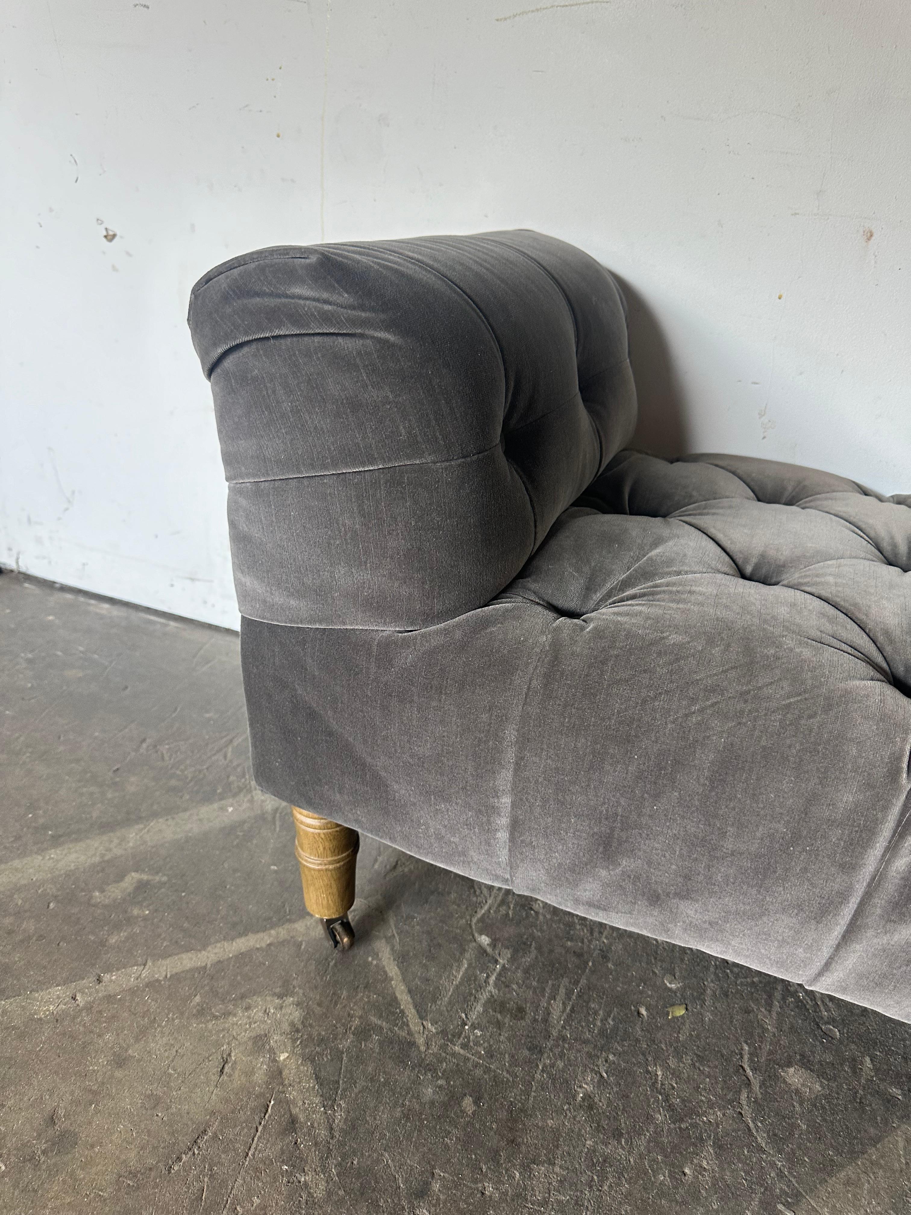 Gorgeous elegant Camille tufted sofa by Restoration Hardware. In excellent condition. Classic silhouette with solid wood legs with wheels. Perfect for the entry hall hall, in front of a bed, or as occasional seating in a living room. In even