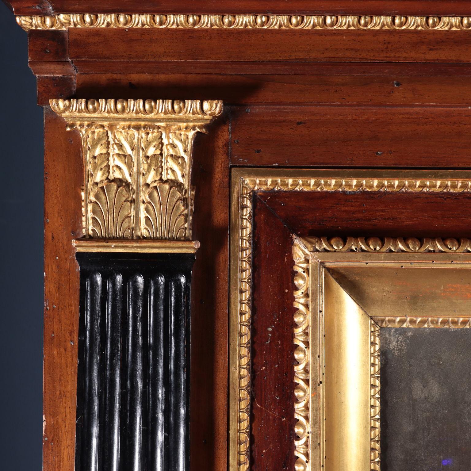 Lombard fireplace set in walnut, with ebonized and gilded parts.
In the lower part, a broken plinth base with ebonized reserves
bounded by successional leaf-carved and gilded battens. In the
upper part a central door with mercury mirror, with groove