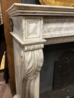 Antique fireplace with a sculpted mantelpiece, in the Empire style (late 19th century).