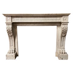 Antique fireplace with a sculpted mantelpiece, in the Empire style (late 19th century).