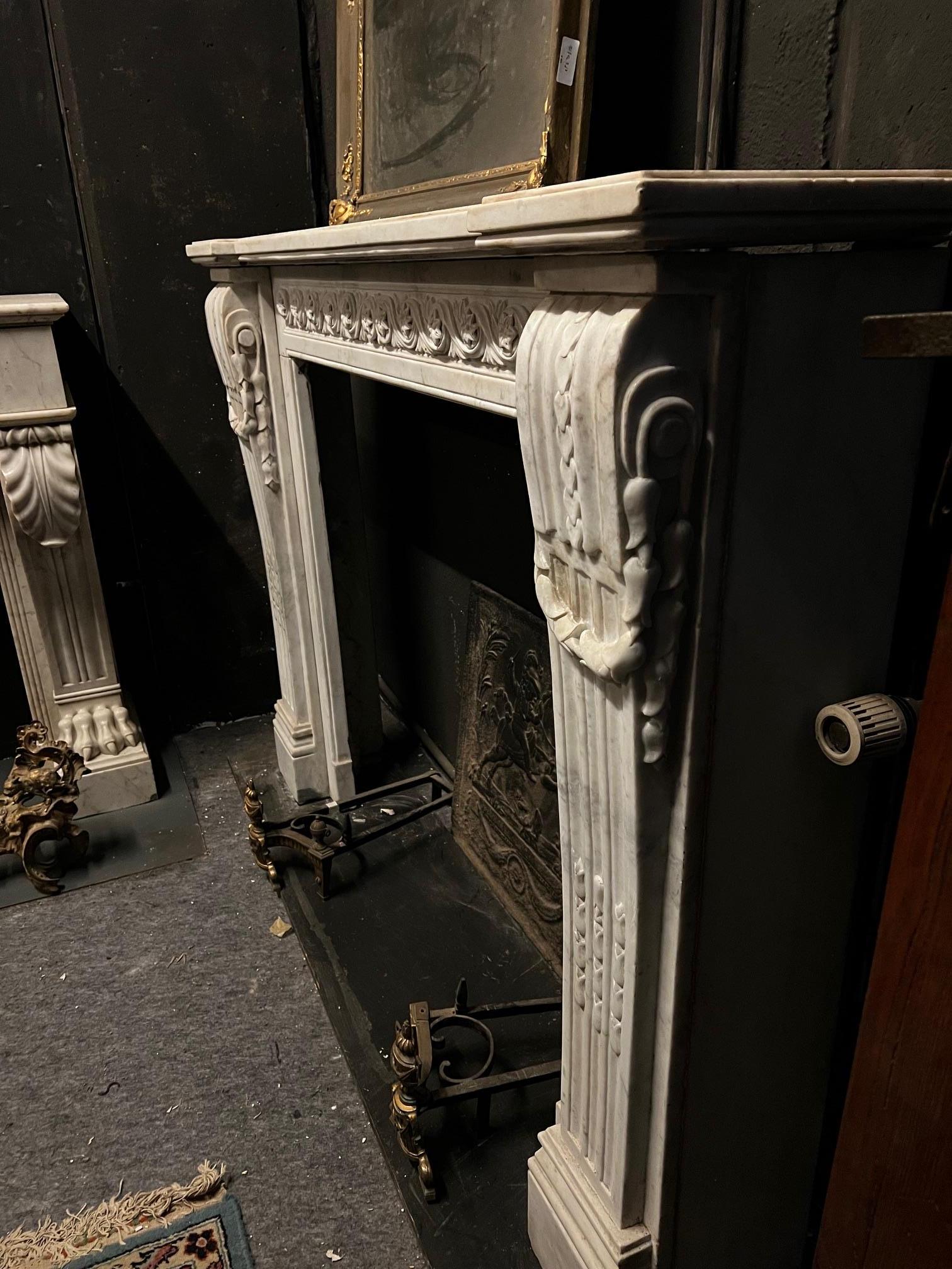 Camino en marmo bianco Carrara, fronte scolpito con motivo di fiori susseguenti Tallado en venta