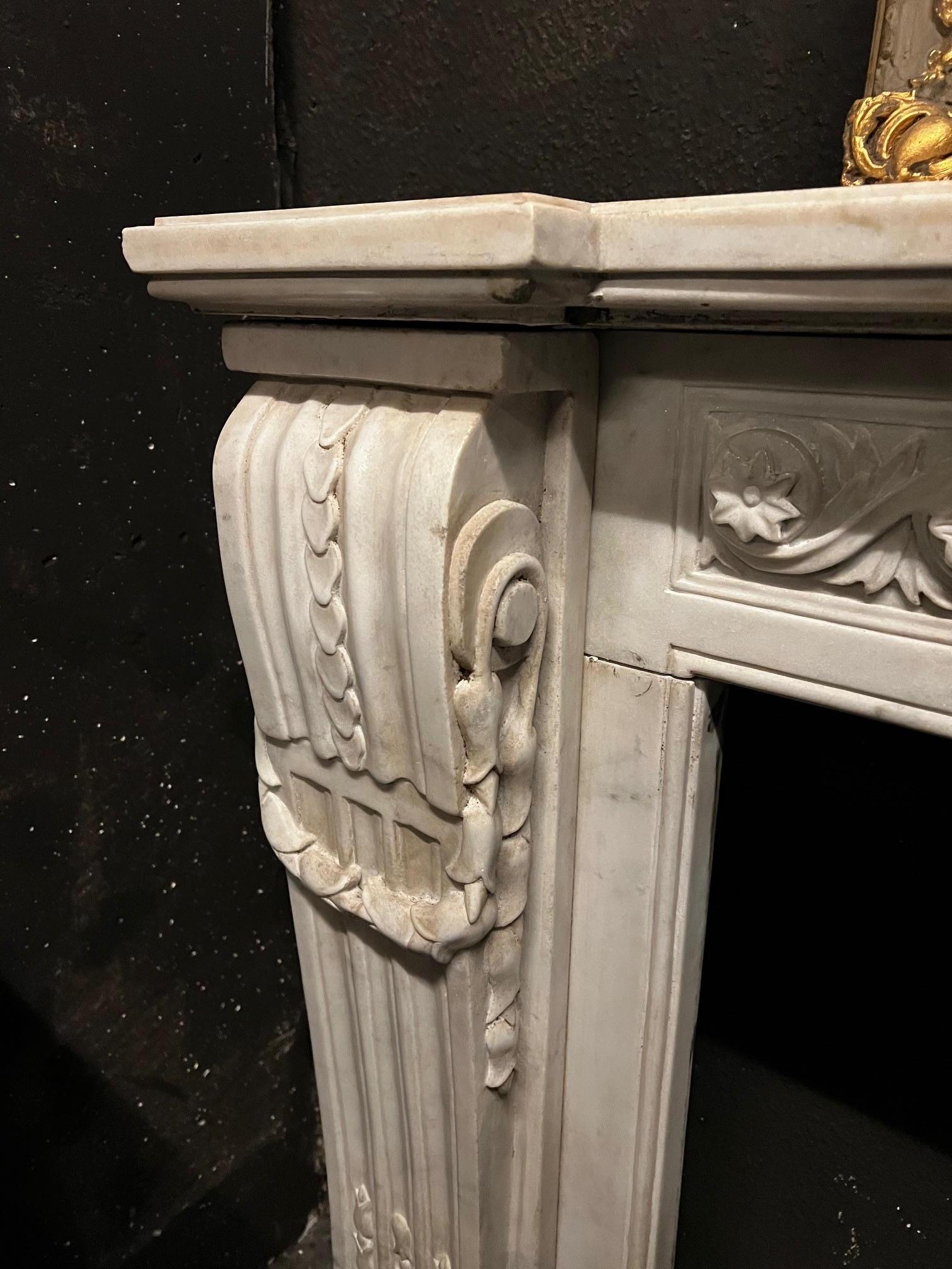 Camino en marmo bianco Carrara, fronte scolpito con motivo di fiori susseguenti siglo XIX en venta