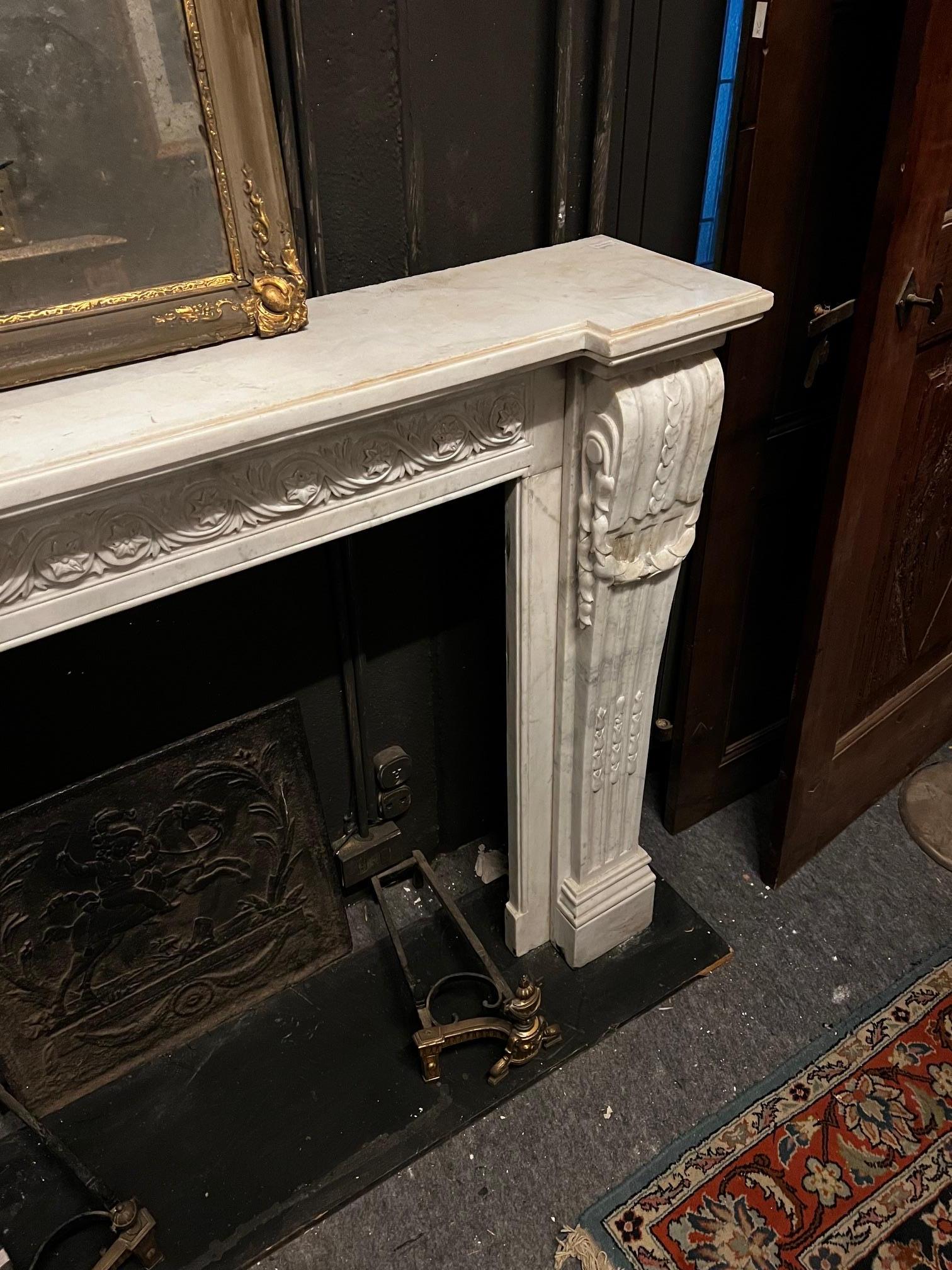 Camino en marmo bianco Carrara, fronte scolpito con motivo di fiori susseguenti en venta 2