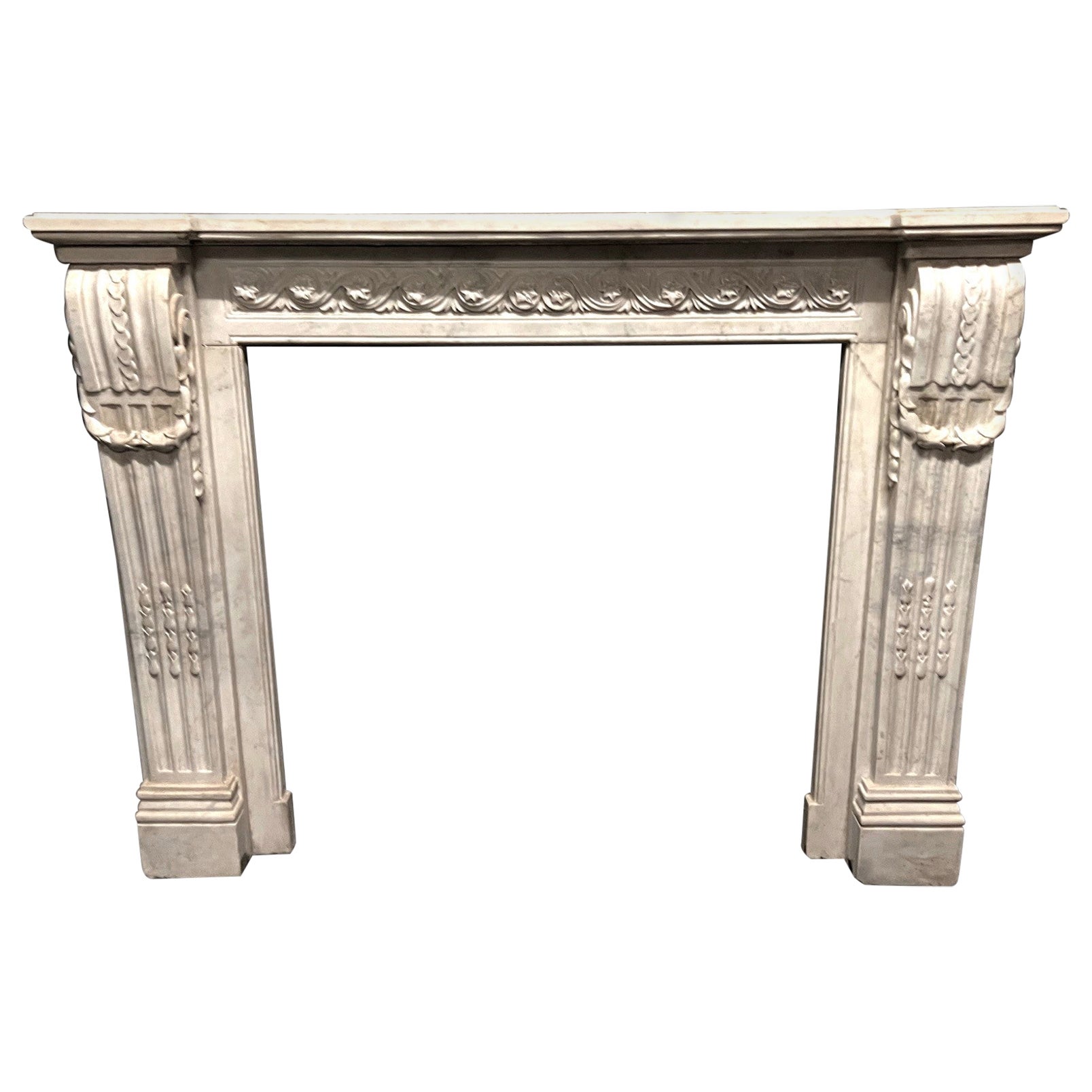 Camino in marmo bianco Carrara, fronte scolpito con motivo di fiori susseguenti