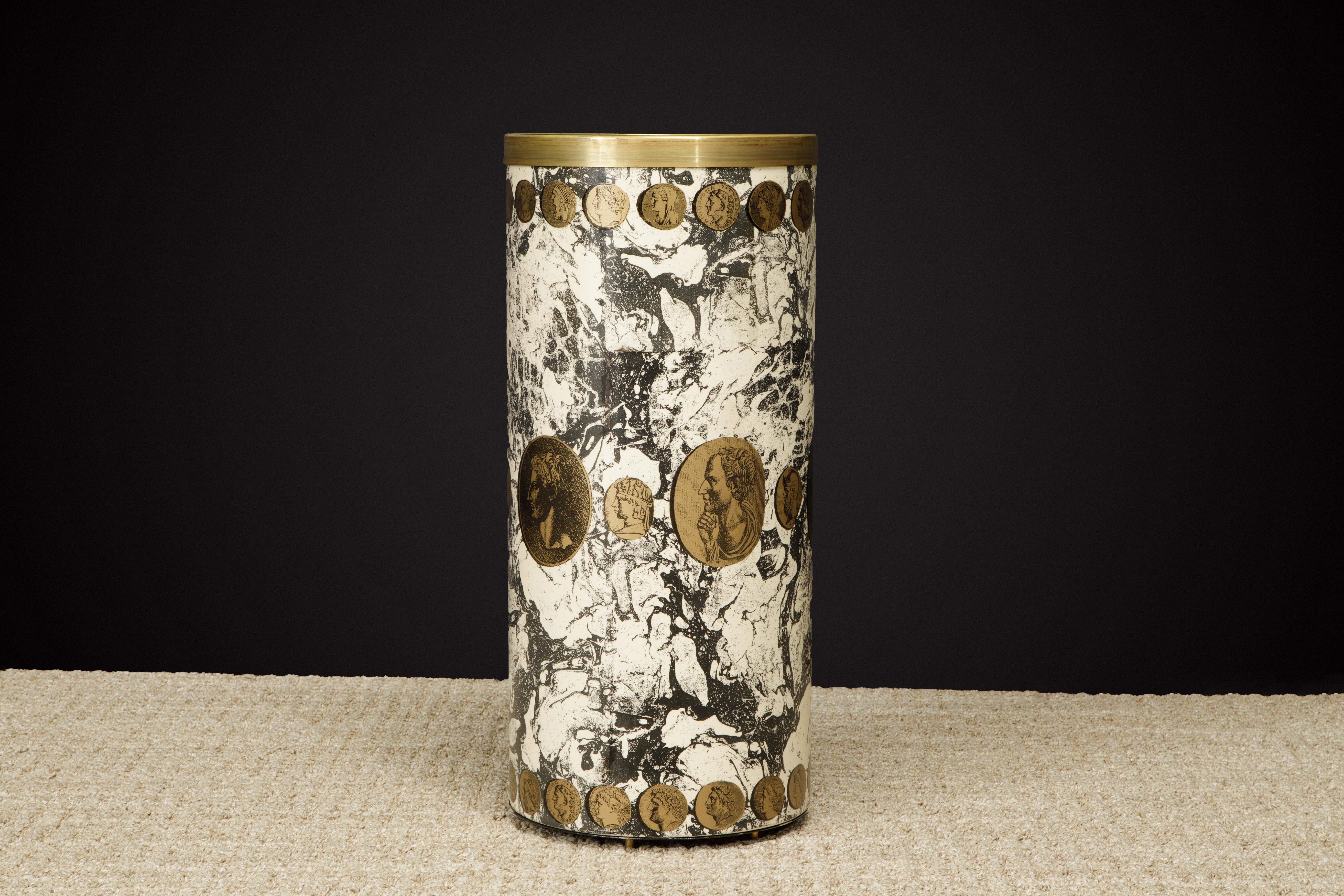 This collectors item is the 'Cammei Marbalia' (Marbled Cameos in Italian) umbrella stand by Piero Fornasetti, circa 1970s, signed underneath. This hefty round umbrella bin is made with lithographic transfer and lacquered metal that has a white and