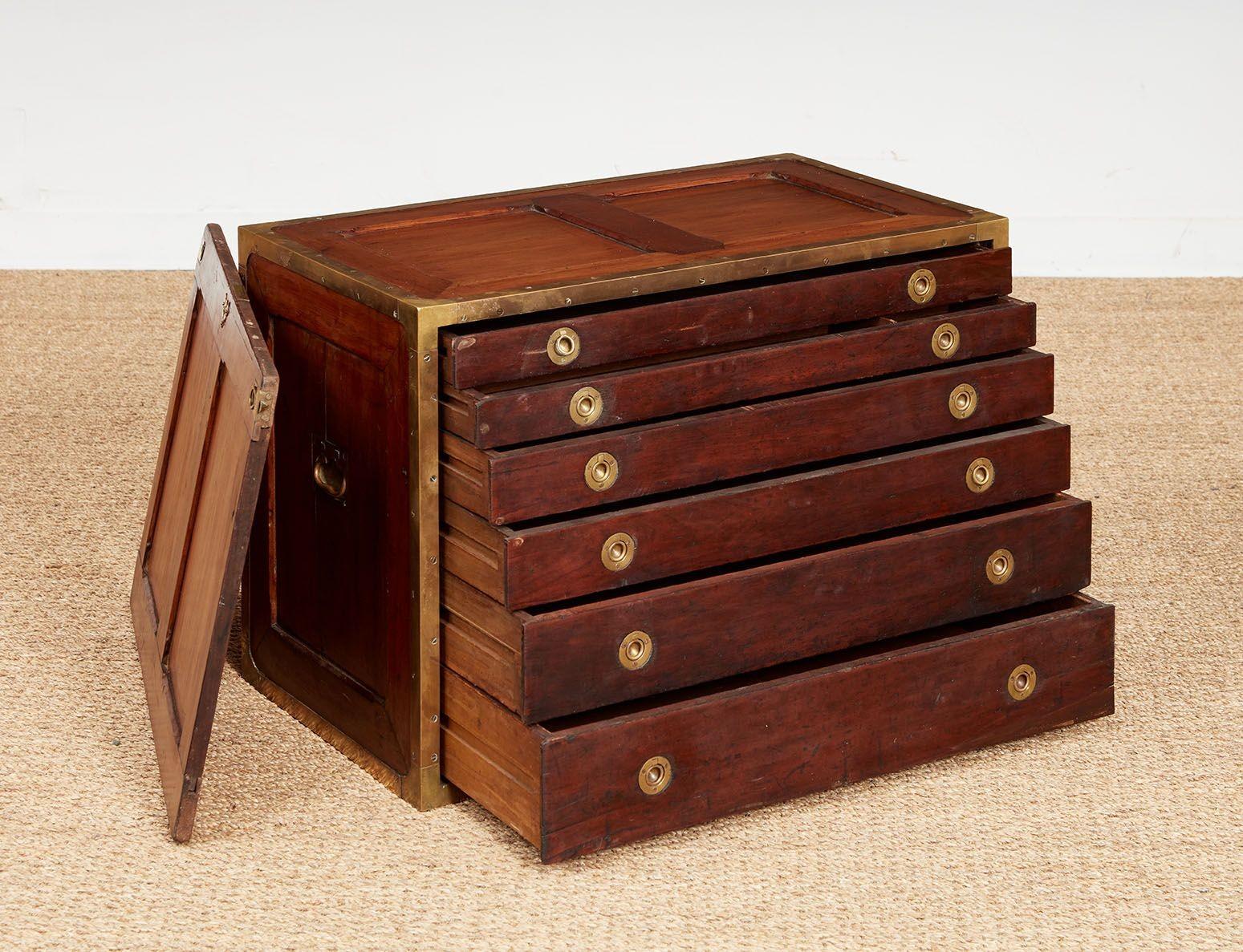 Early 19th century English campaign traveling box or chest finished all the way around with rebated brass edges and corners affixed with flush brass screws, also having brass carrying handles and lock, with the sides of pale mahogany divided panels