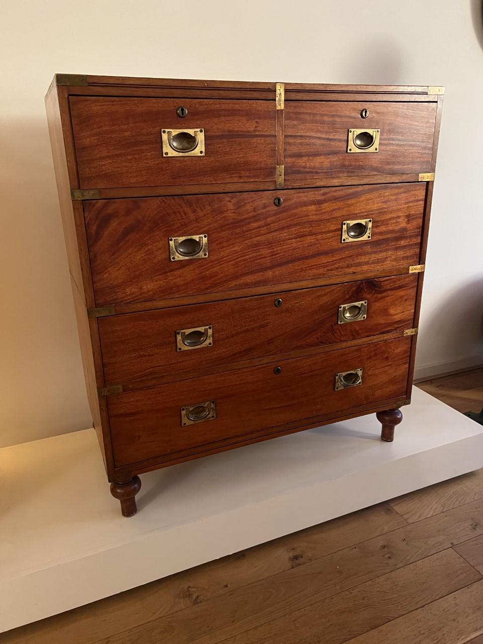 Mahogant & brass campaign chest or officers chest that was used by British officers to store their personal belongings and clothing / uniforms.
Beause thes officers had to change location regularly these cabinest travelled a lot and therefore could