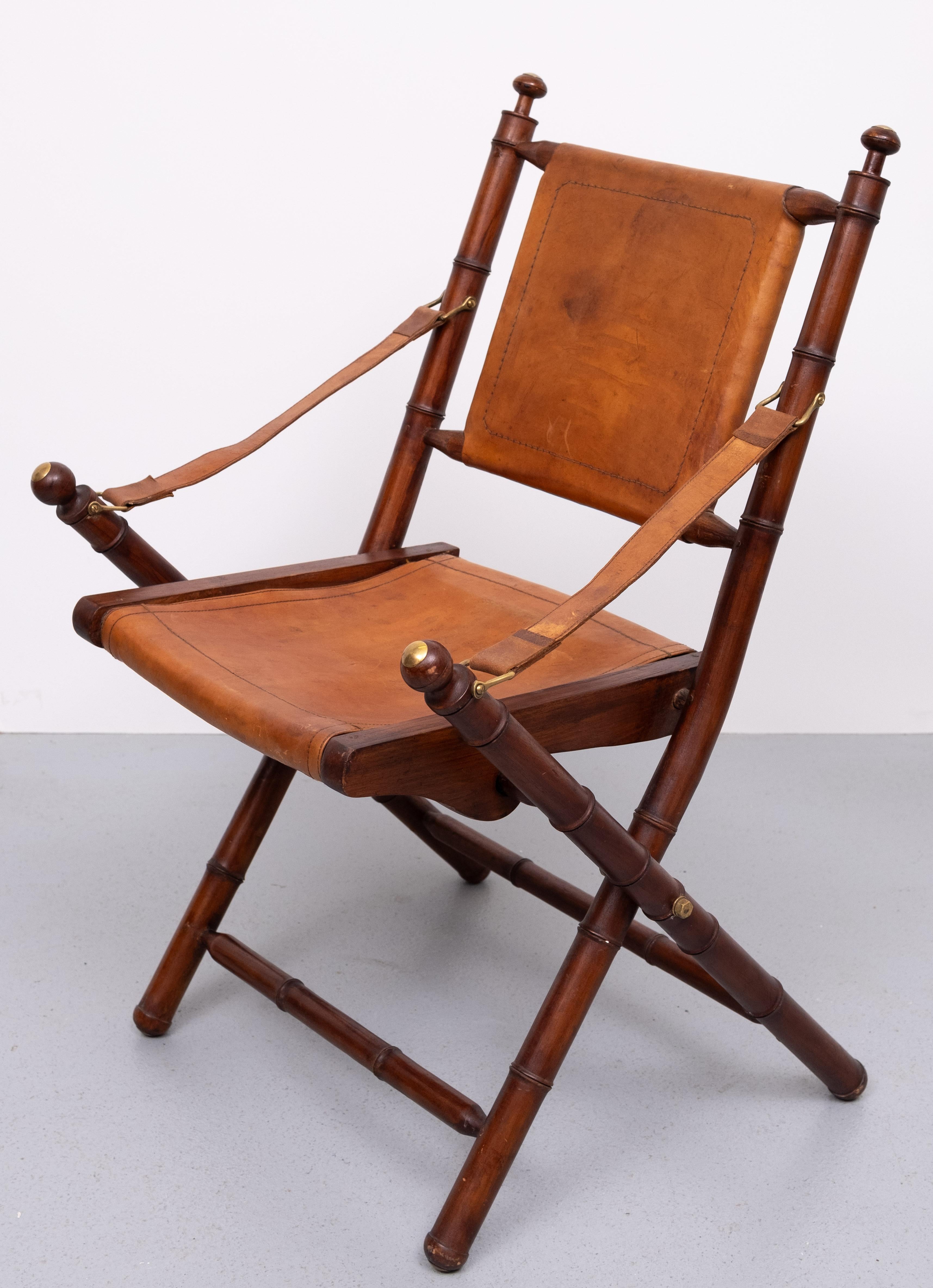 Very nice attractive  20th century Faux Bamboo & Brown Cognac color Leather Folding Campaign Safari Chair with Sling Arms & Brass Mounts.
good condition . 
