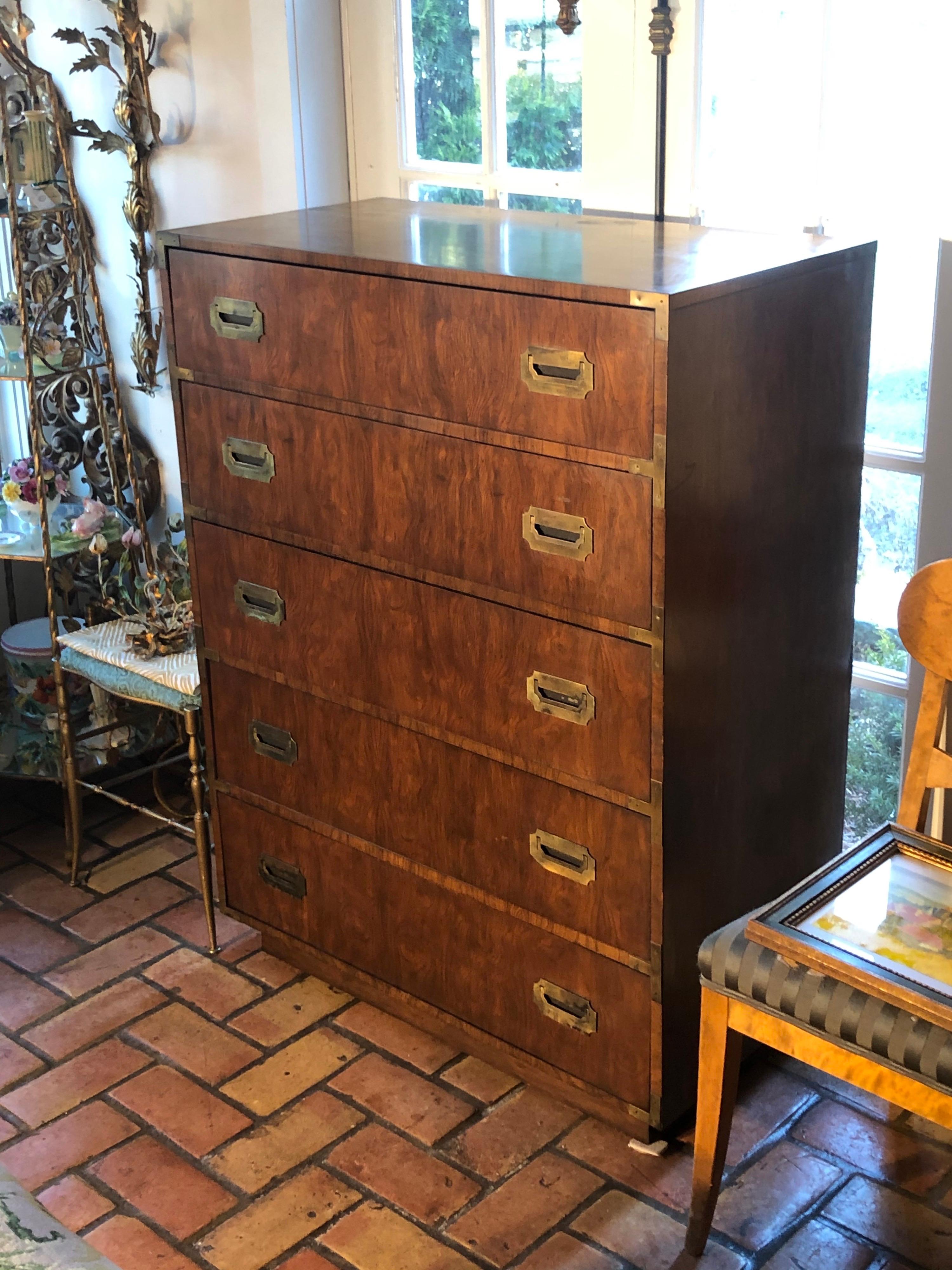 Campaign highboy chest of drawers by Dixie. Classic brass hardware and nice burl wood style wood. Five dovetailed drawers for ample storage with a platform base typical of the Mod 1970s.