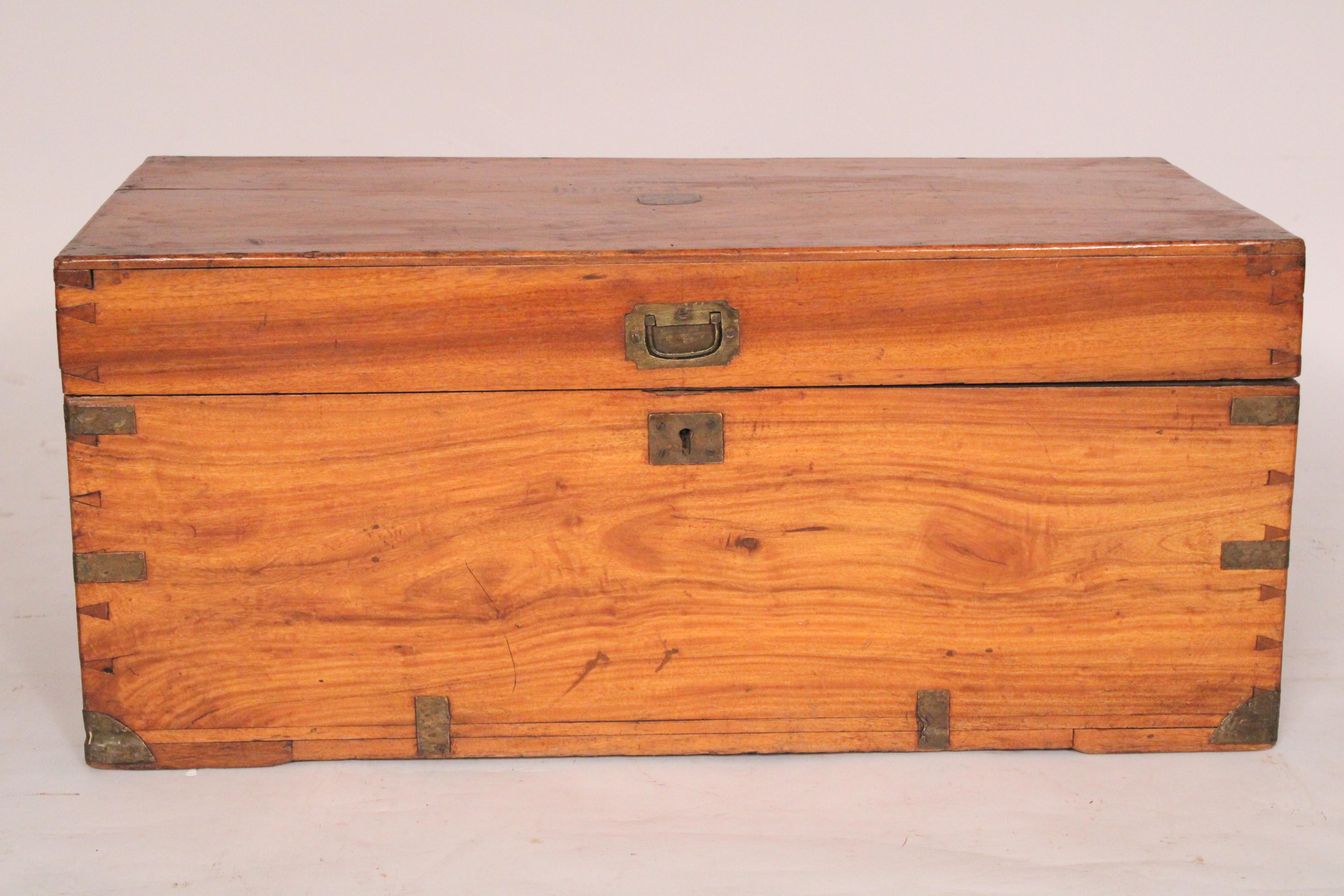 English made campaign style camphor wood trunk with campaign style brass mounts, circa 1910. With a rectangular top with inscription that reads 