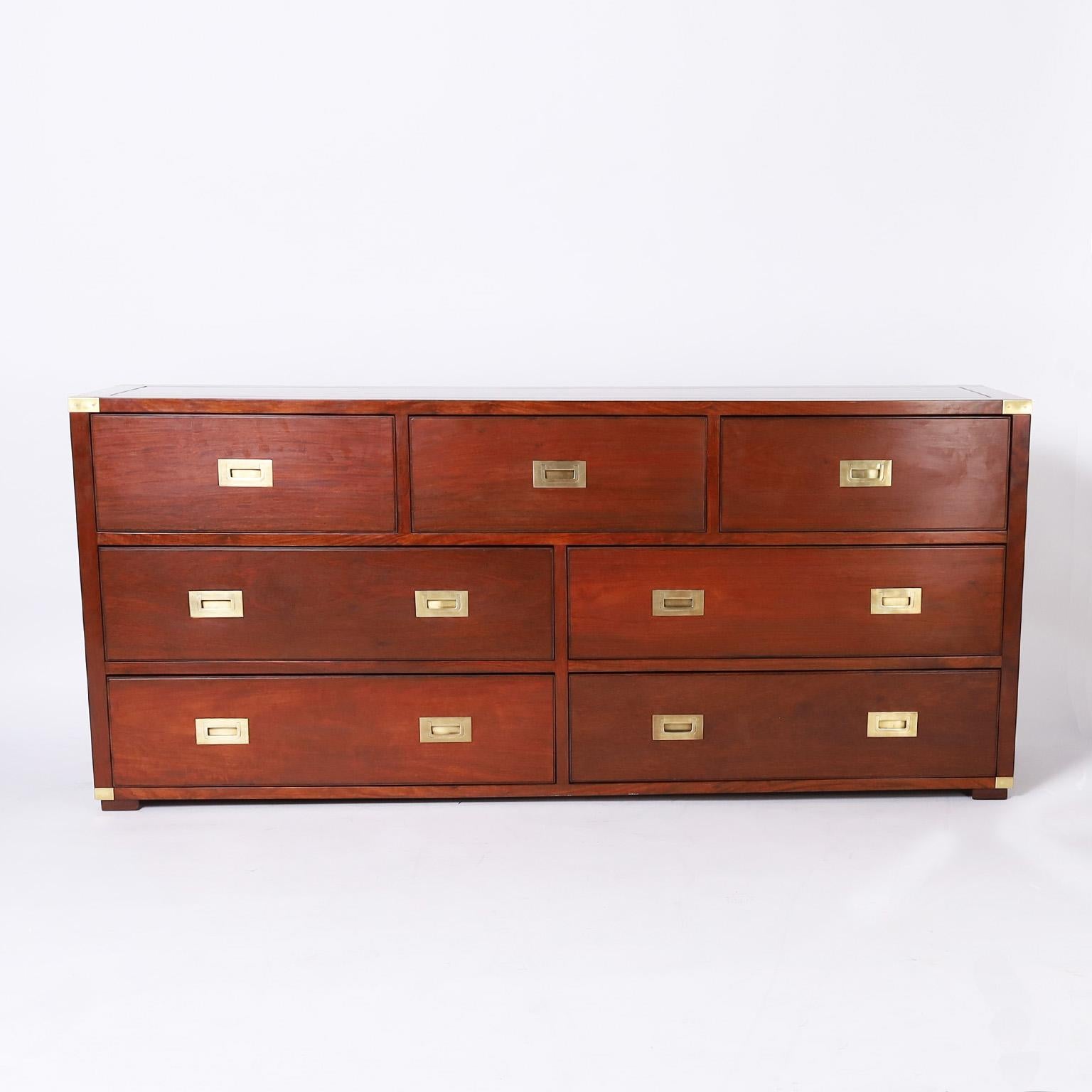 Campaign style chest of drawers or dresser crafted in mahogany in a chic combination of traditional campaign and mid century modern, with plenty of storage, brass hardware, and block feet. This piece was likely made by Charlotte Horstmann of Hong
