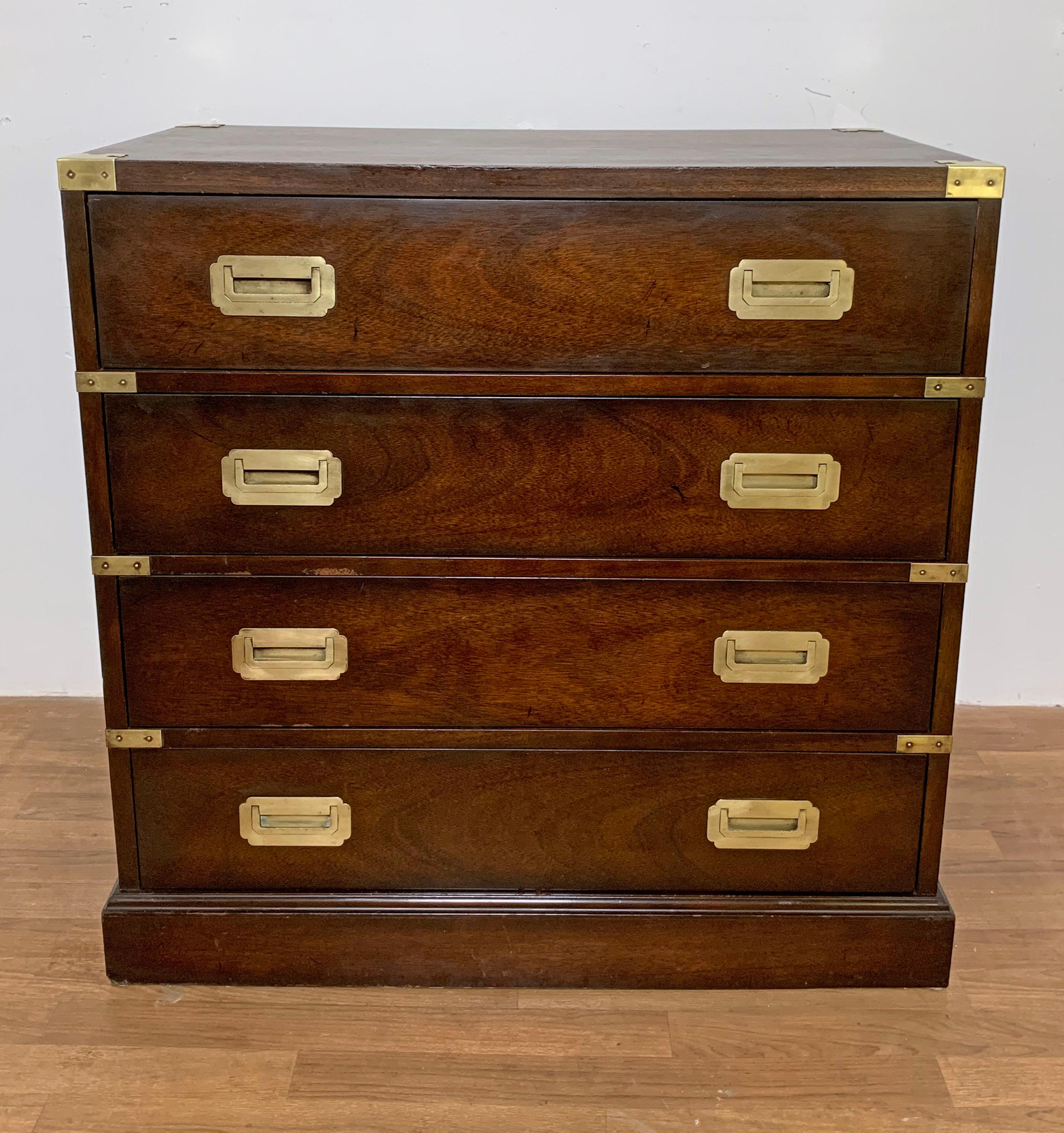 A British made four drawer Campaign style chest of drawers in mahogany, featuring brass corners, strapping on all drawers, baseboard molding and working lift handles.