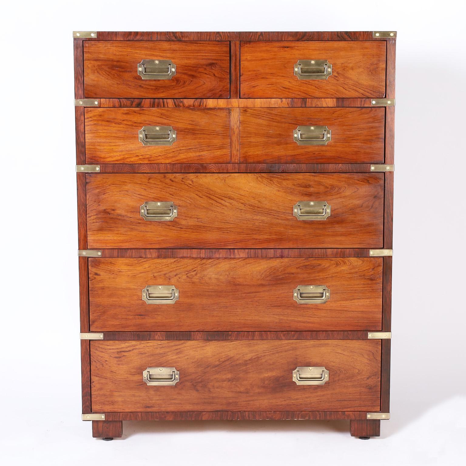 Mid century British colonial style tall chest crafted in rosewood with dramatic wood grains, two small drawers at the top and four below, brass campaign hardware, and block feet with adjustable pads. Perfect combination of modern and traditional