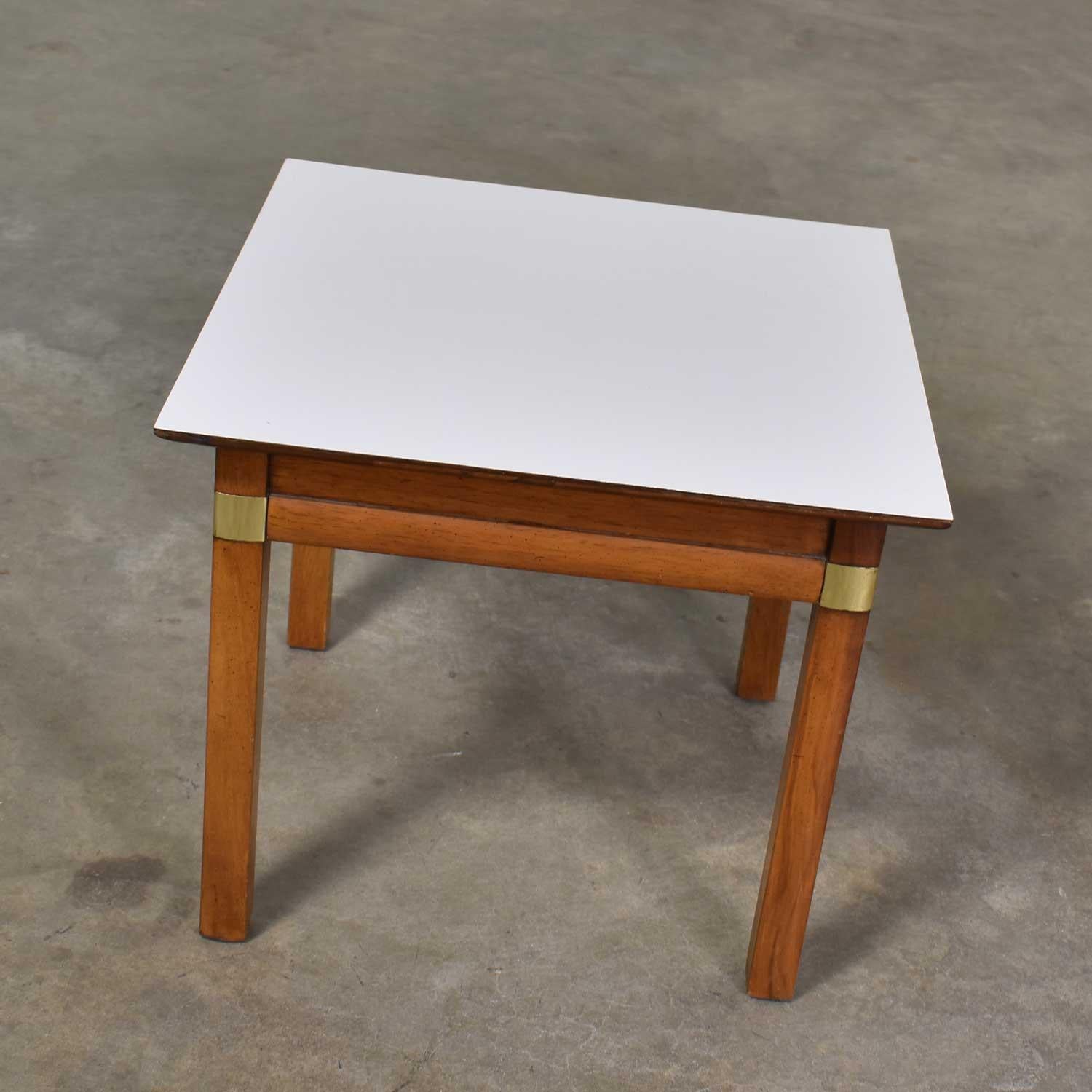 Handsome and useful small square campaign style side, end, or occasional table with a white laminate top made by Hickory Furniture Manufacturing. It is in wonderful vintage condition. The wood does have signs of age but nothing outstanding. Please