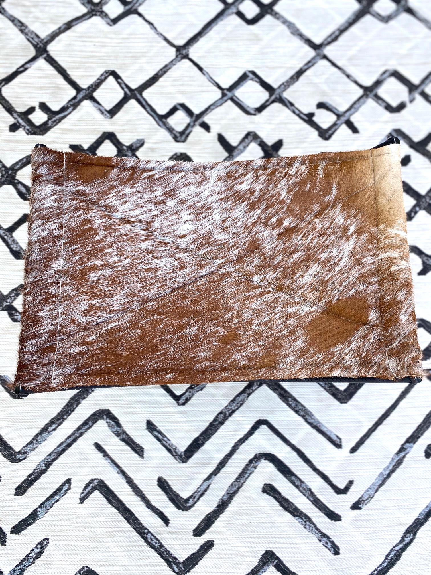 Contemporary Campaign Style Stool with Brown and White Cowhide Seat and Black Iron Base