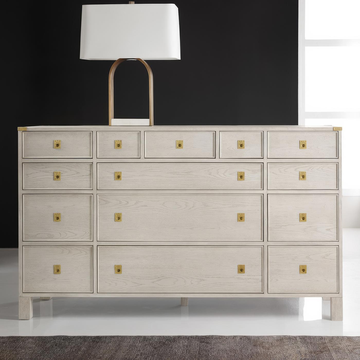 Classic campaign furniture, this refined dresser combines traditional military aesthetics with contemporary craftsmanship. The white-painted oak construction features a carefully wire-brushed finish that emphasizes the wood's natural grain, while