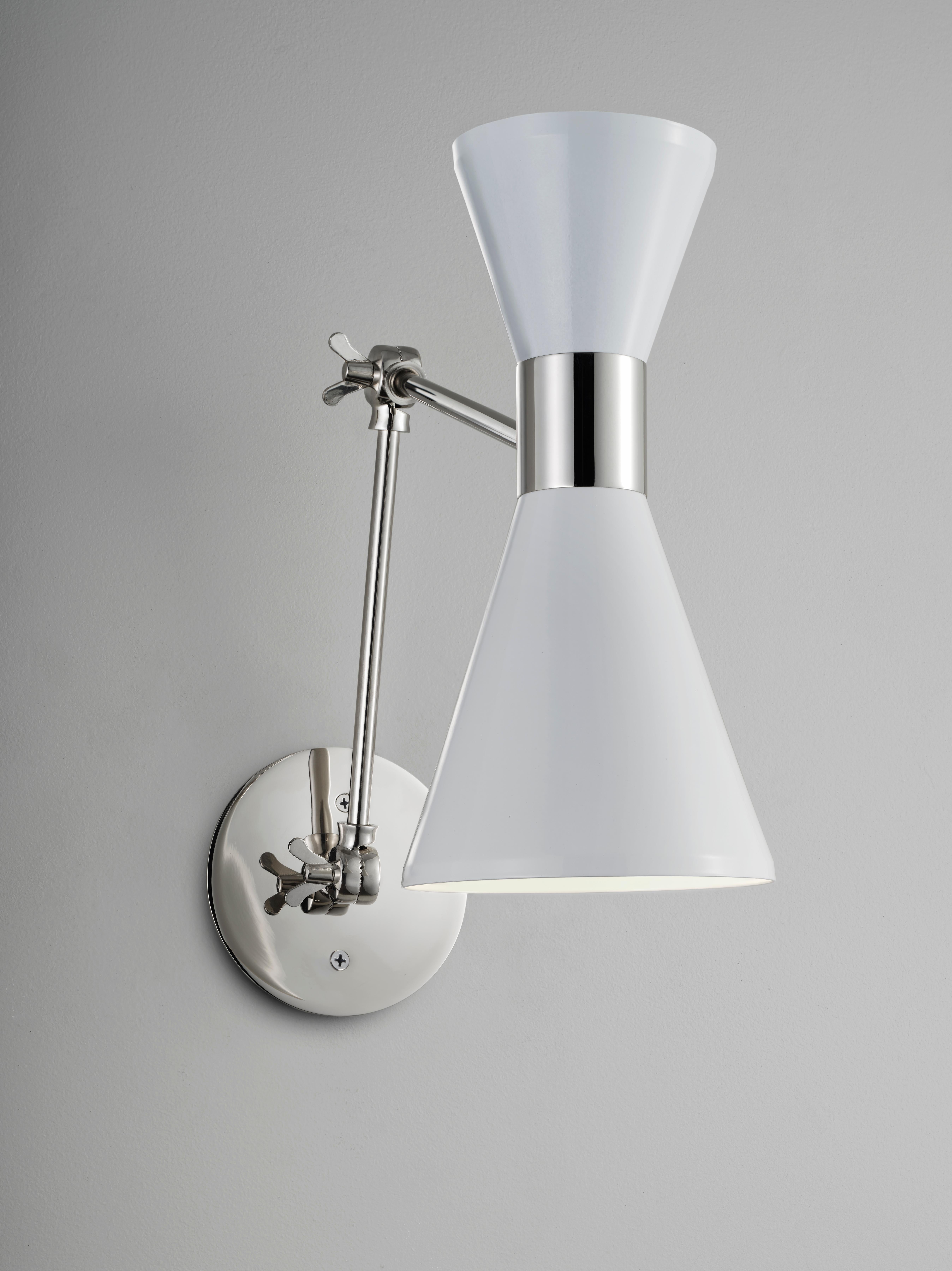 The Campana articulating wall lamp is shown in polished nickel and stark white enamel. The wide band and distinctly beveled edge makes the Campana a strong design statement. Swiveling head allows for cone adjustment. The spun aluminum cones are