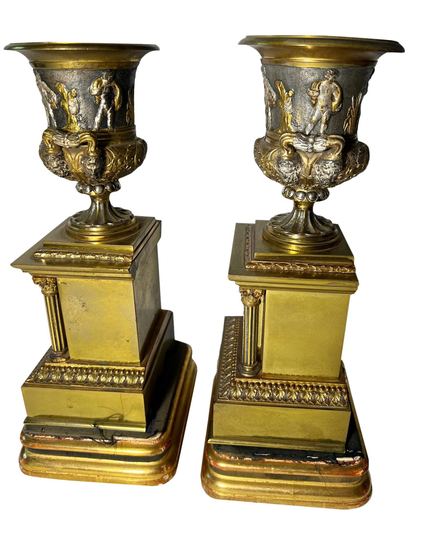 Ein Paar Bronze-Urnen auf Holzständern mit Säulen. Jede Urne ist mit dem Leben der Römer in einem silbernen Überzug mit Bronzefiguren umgeben. Außergewöhnliche Qualitätsarbeit. Italien, um 1880.