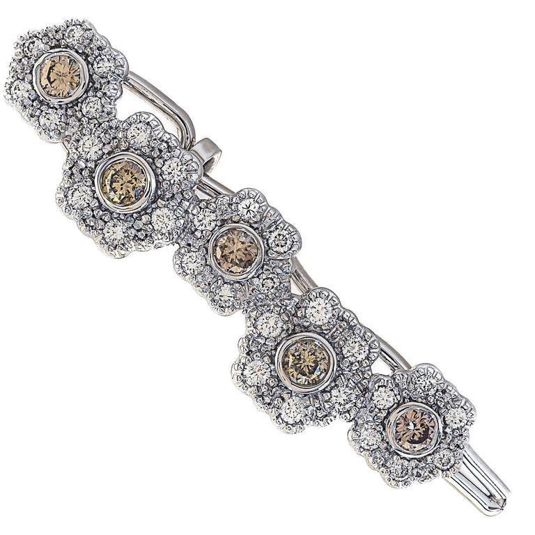 The perfect hair accessory for weddings, proms, or other special events. This 14k white gold barrette features five champagne colored diamonds accented with 0.53 cttw of white diamonds in a floral design. The clips stay put through unique hairpin