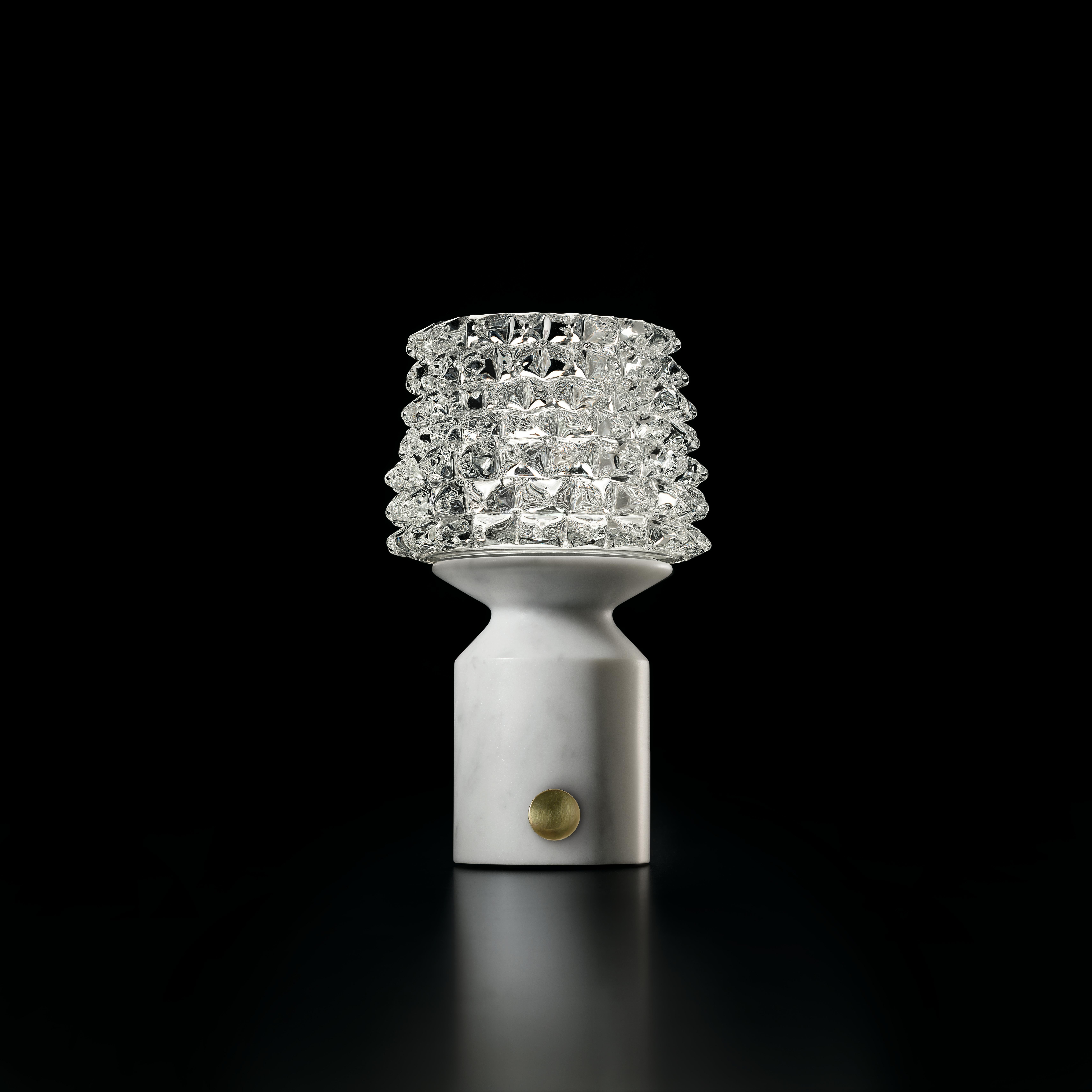 Camparino is an elegant, sophisticated table lamp that brings together past and present in a single, compact piece. On the one hand it reflects Murano glassmaking tradition, in that it uses the “rostrato” technique; on the other, it represents the
