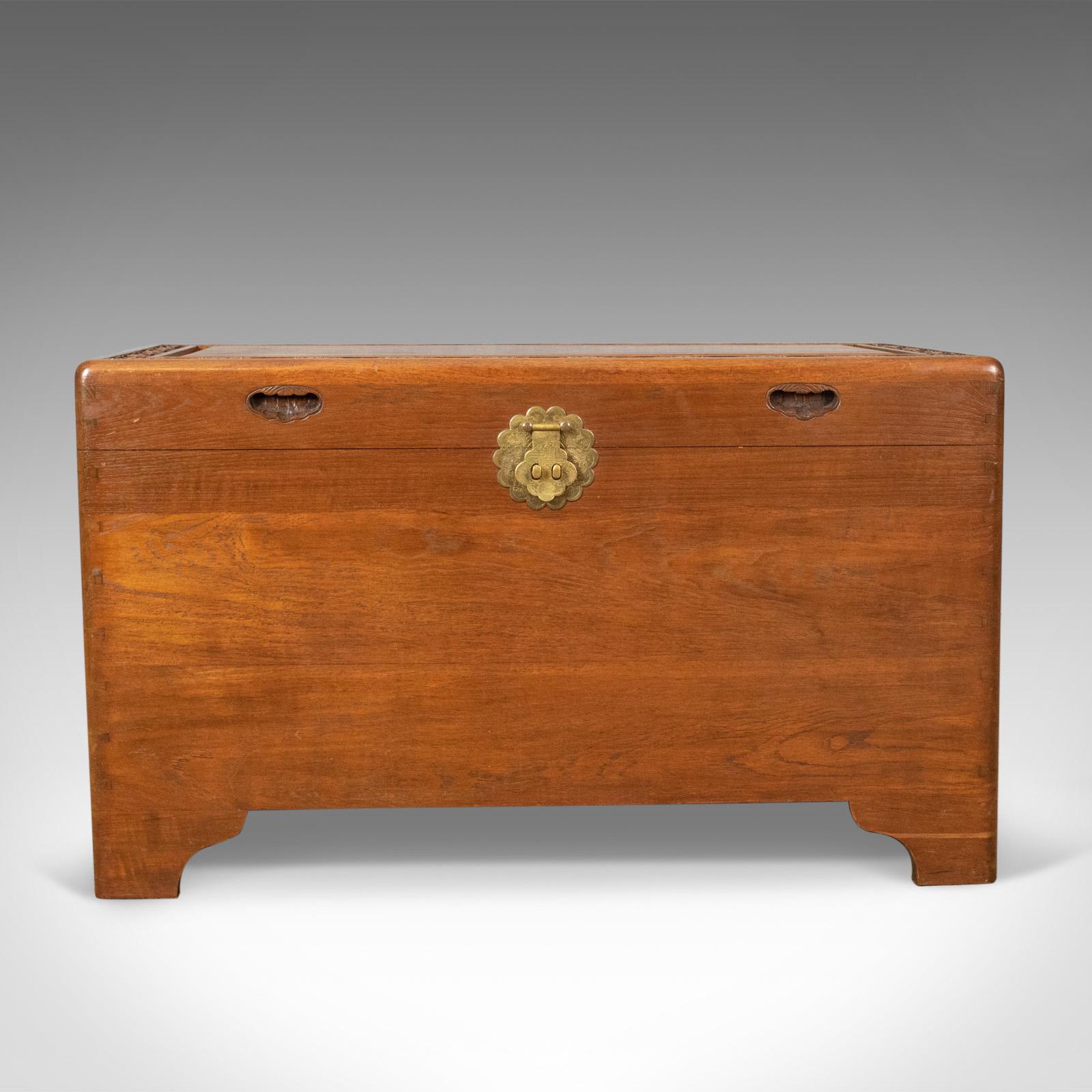 This is a camphor wood chest, a carved, oriental, trunk dating to the late Art Deco period, circa 1940.

Of quality craftsmanship and stock
Attractive grain interest in warm russet hues
Solidly constructed with brass handle, etched back plate