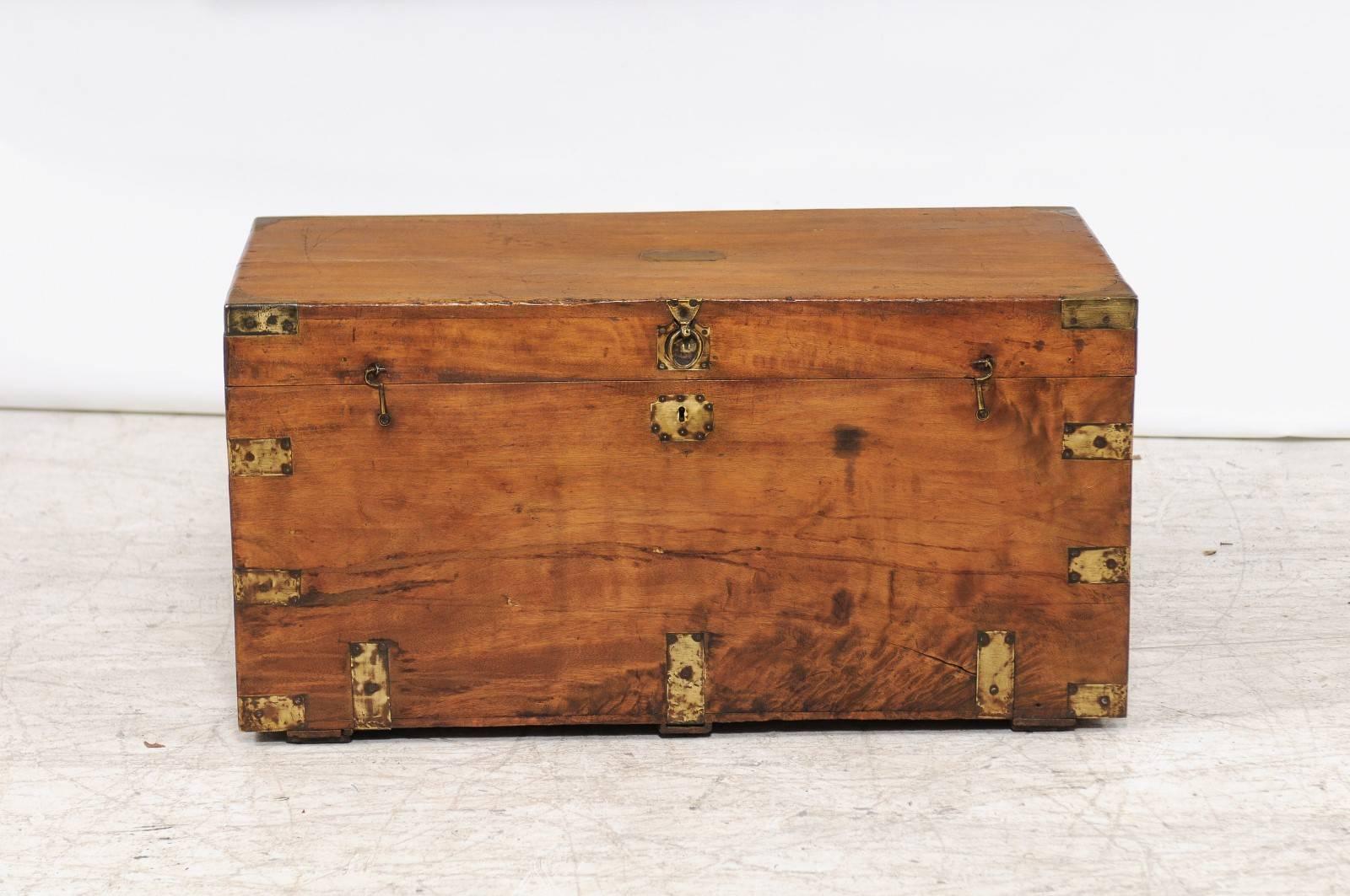 A camphor wood trunk with brass braces and hardware made for the English market, late 19th century. This camphor wood trunk features a rectangular lid adorned with a brass tag and braces in each corner, opening to reveal a great storage compartment,