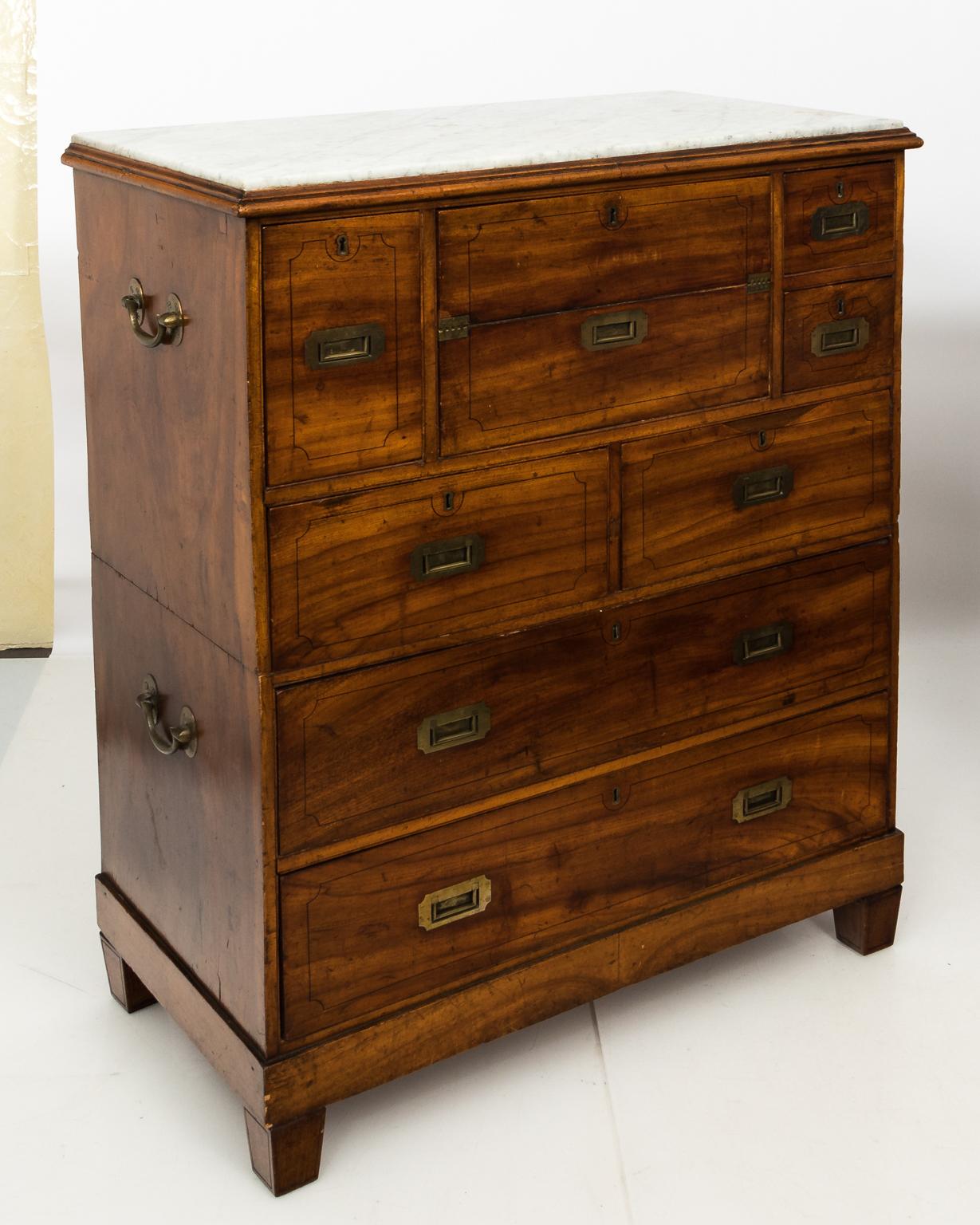 Camphorwood, two-part marble top British Campaign chest with 7 drawers and an embossed leather desk surface. Brass details and recessed pulls. Originally carved feet and a set of 4 optional bun feet.
