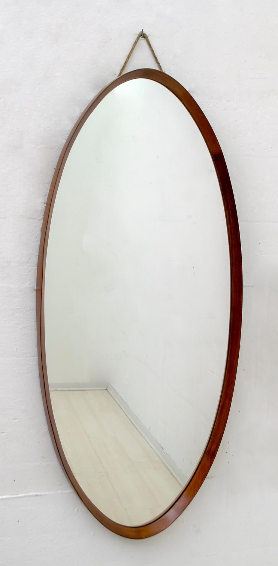 Oval mirror in curved walnut, made in Italy in the 1970s, attributable to Campo e Graffi for Graffi Home.
The frame has been polished.